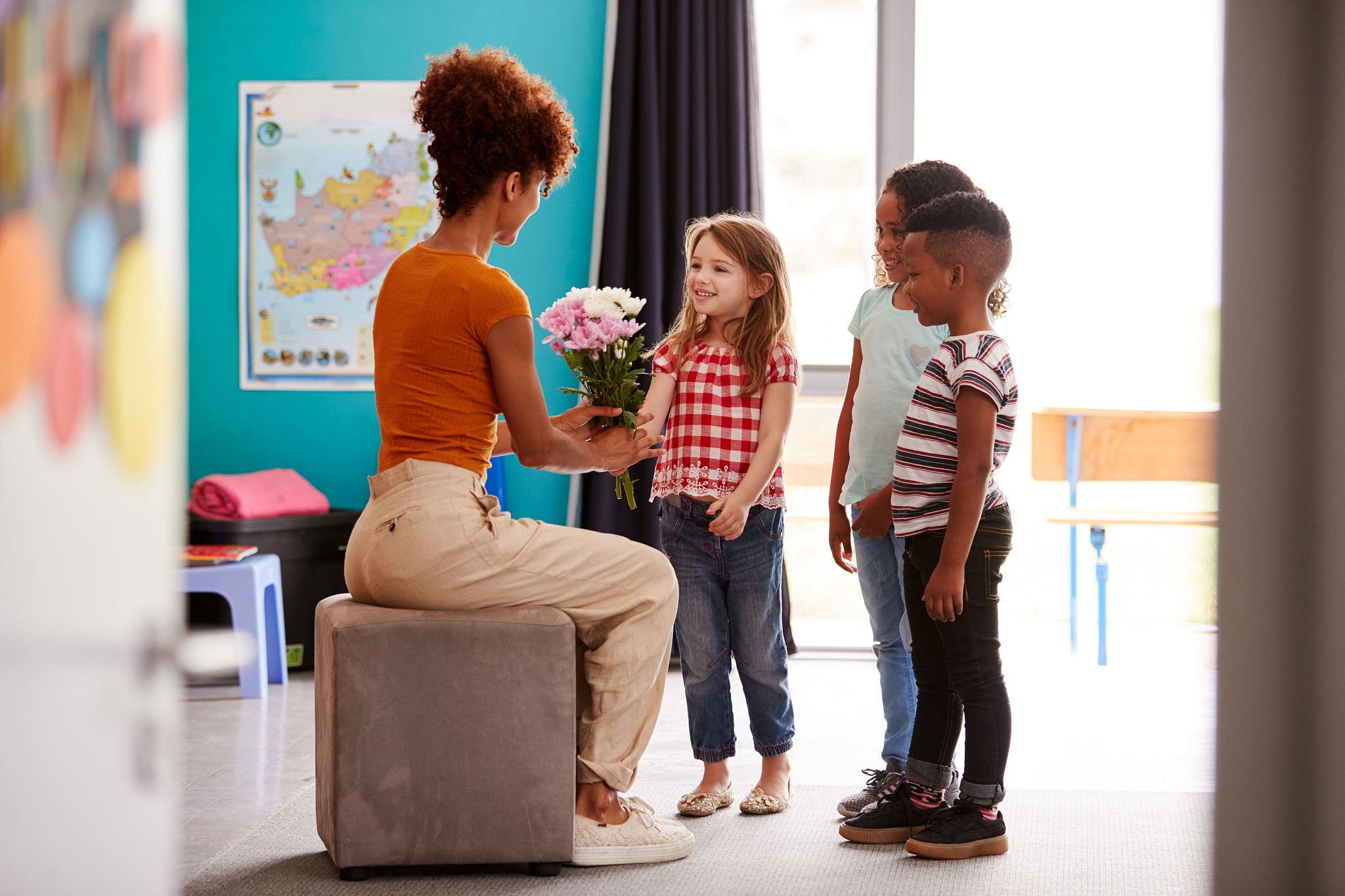 group of elementary school pupils giving female teacher thank yo
