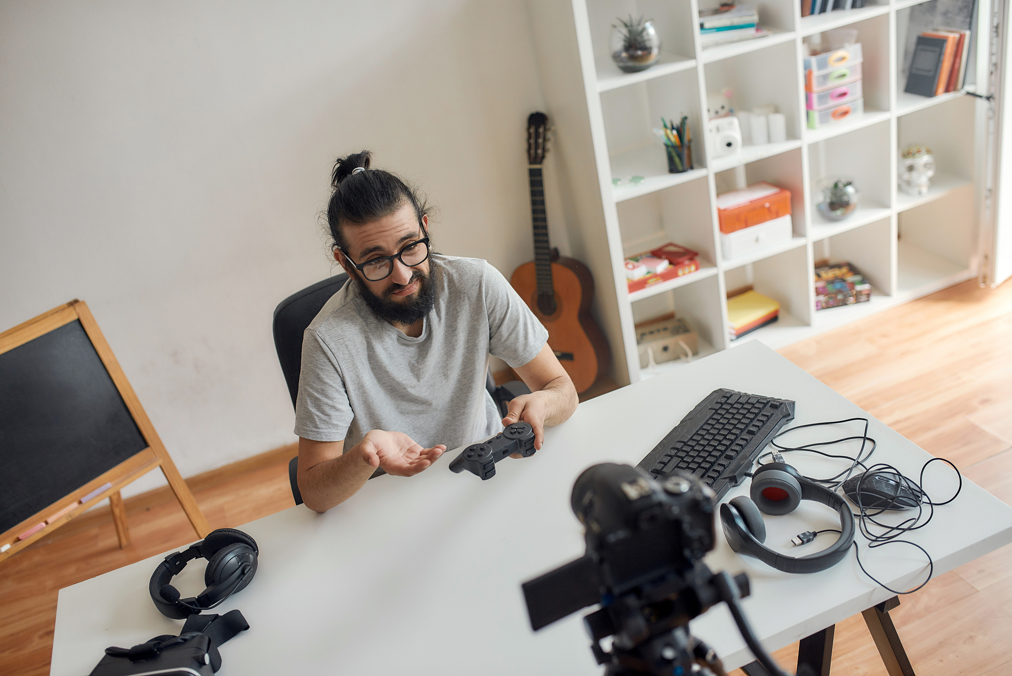 male technology blogger in glasses looking dissatisfied, holding