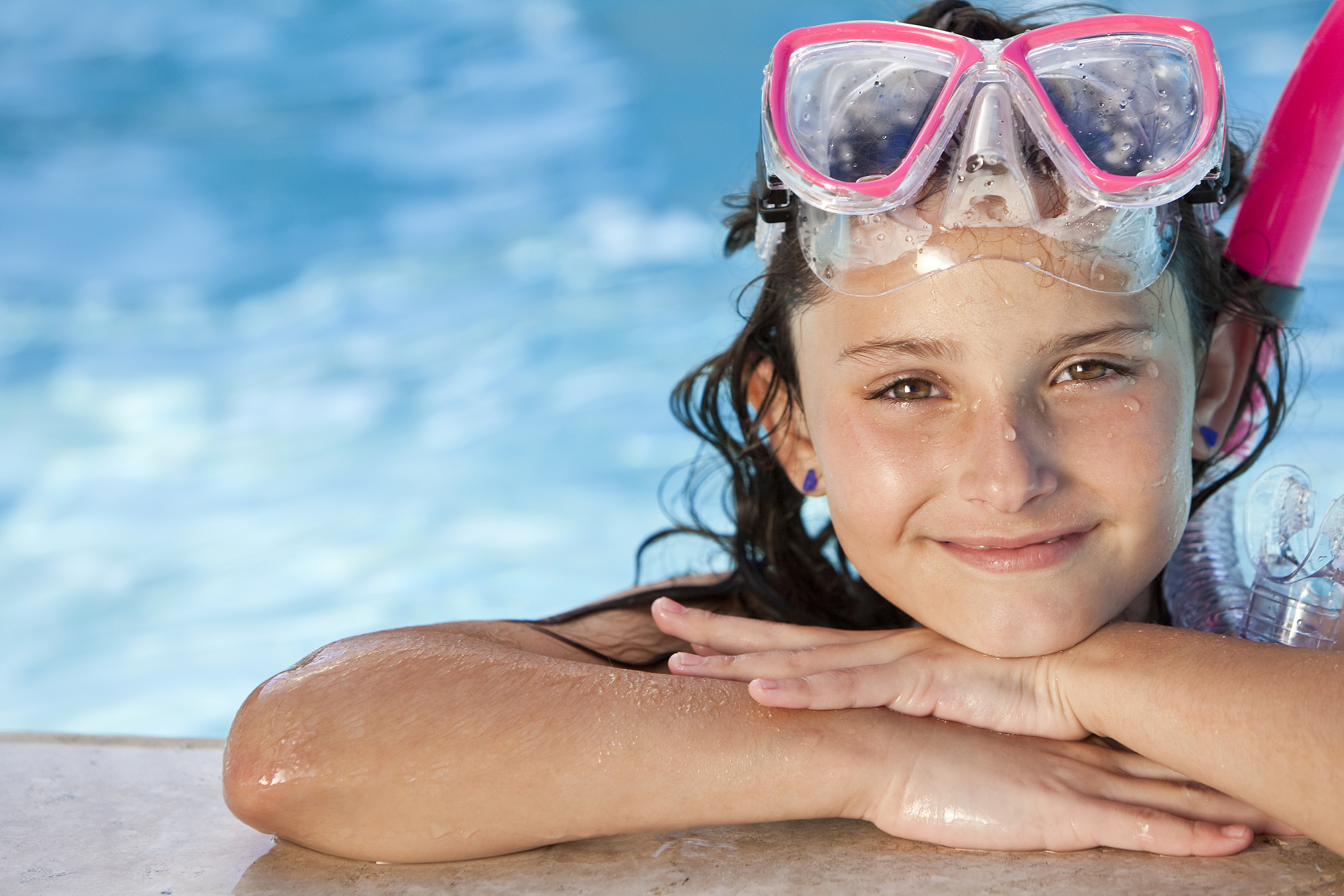 happy girl child wearing snorkel gear at poolside