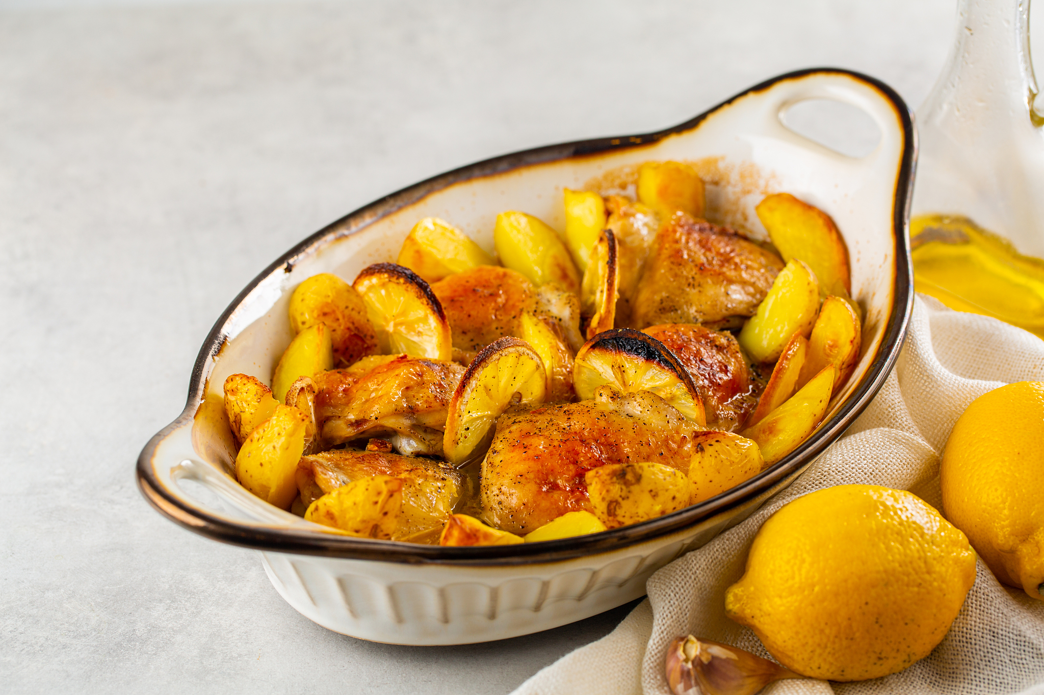 baked lemon garlic chicken and butter with potato. light grey ba