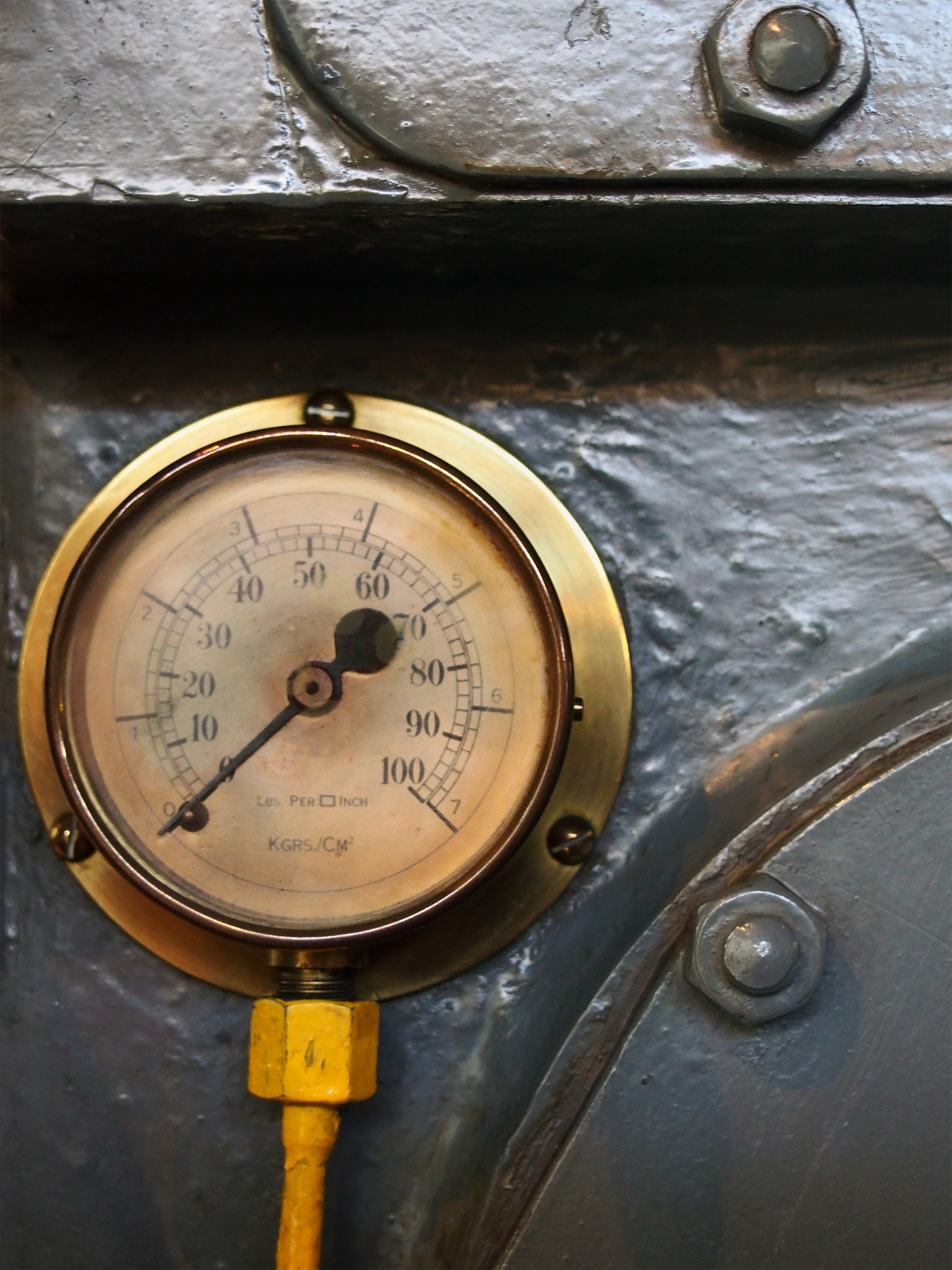 an old brass pressure meter with a round scale with numbers on a