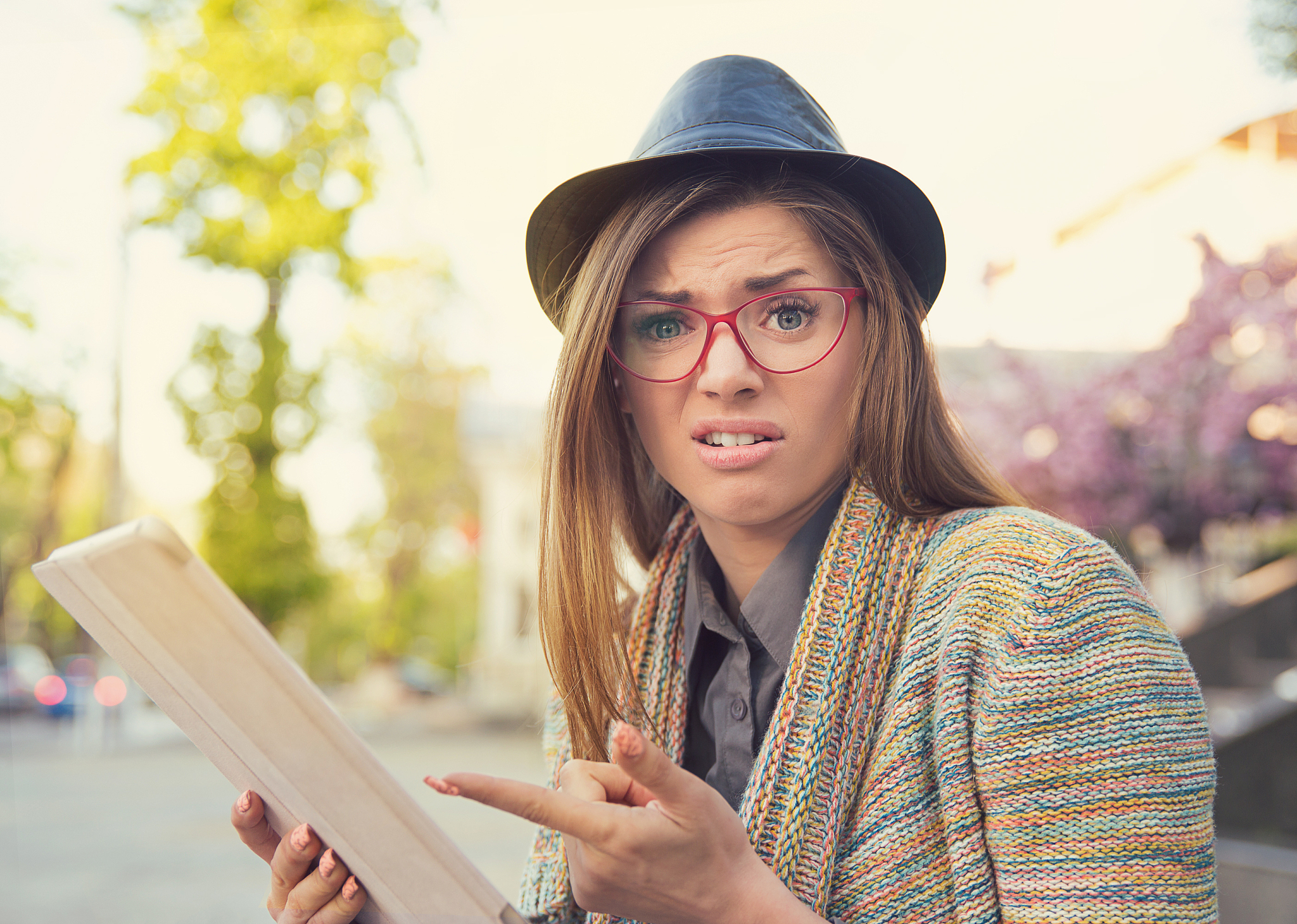 upset young woman with tablet looking at camera