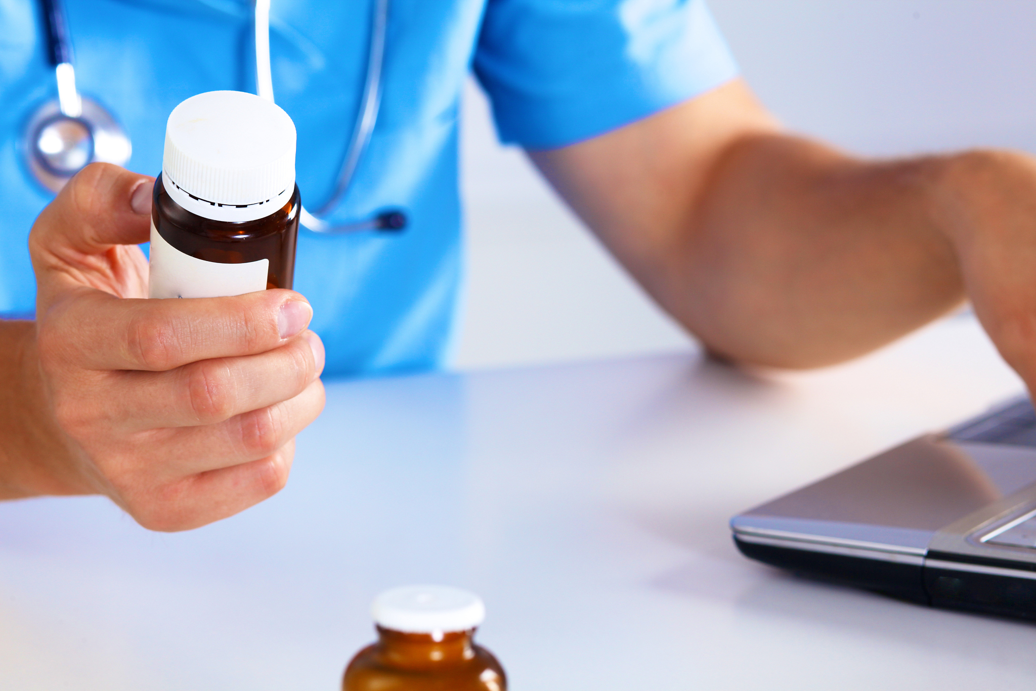 the doctor writes a prescription pill on the computer