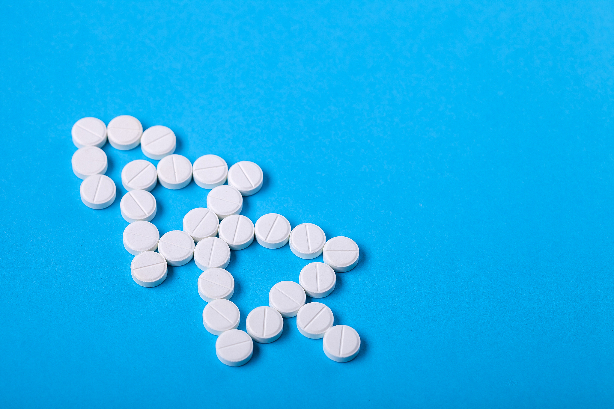 a christmas tree laid out of white round pills.