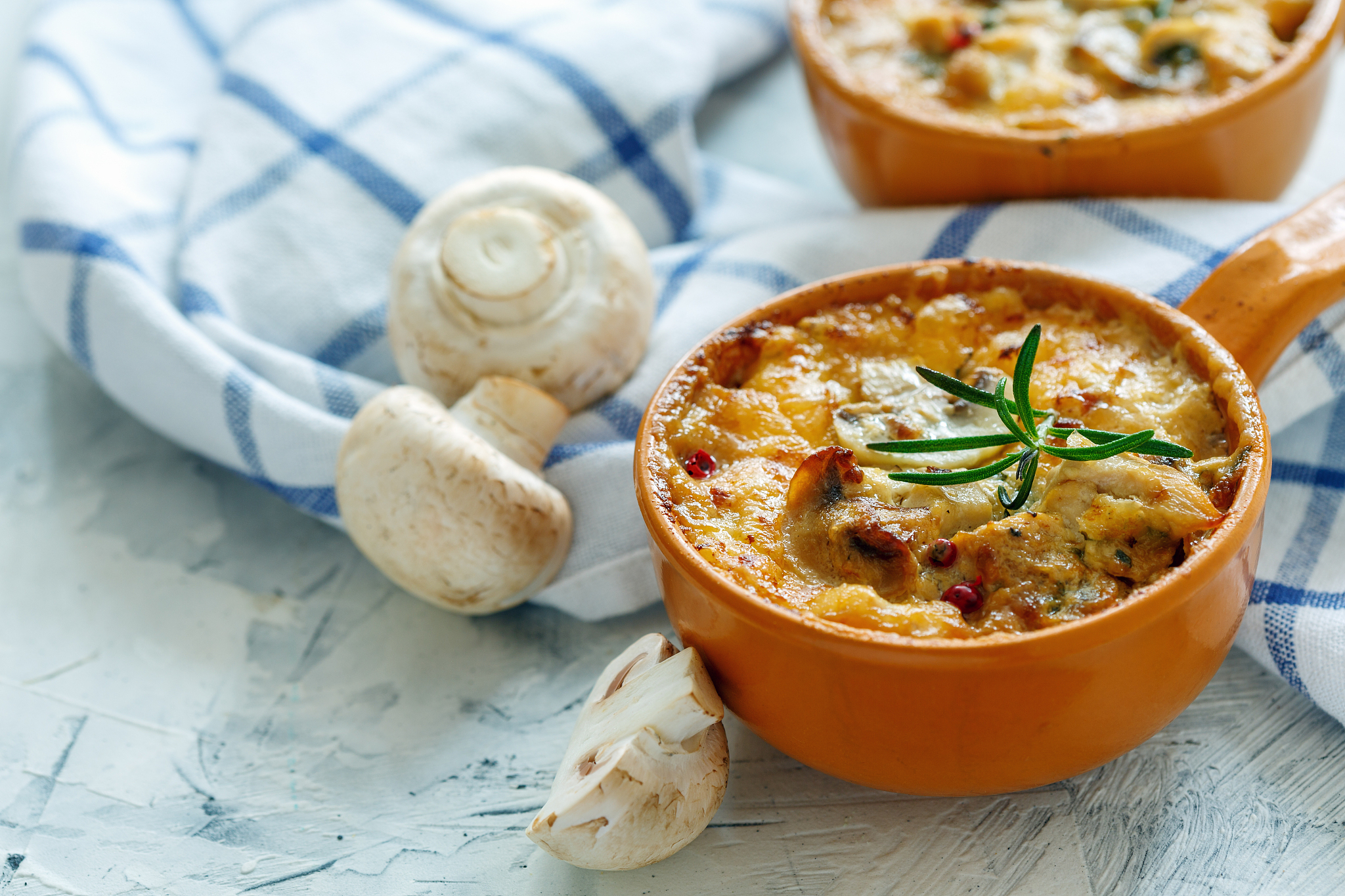 roasted mushrooms, chicken and cheese gratin in pan.