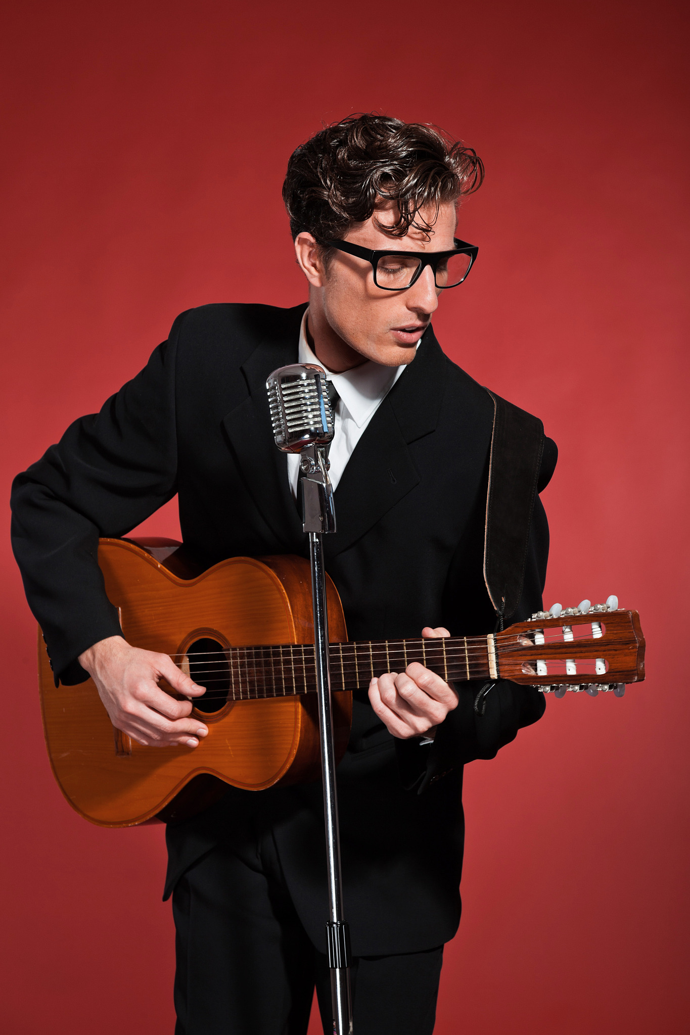 retro fifties musician with glasses playing acoustic guitar.