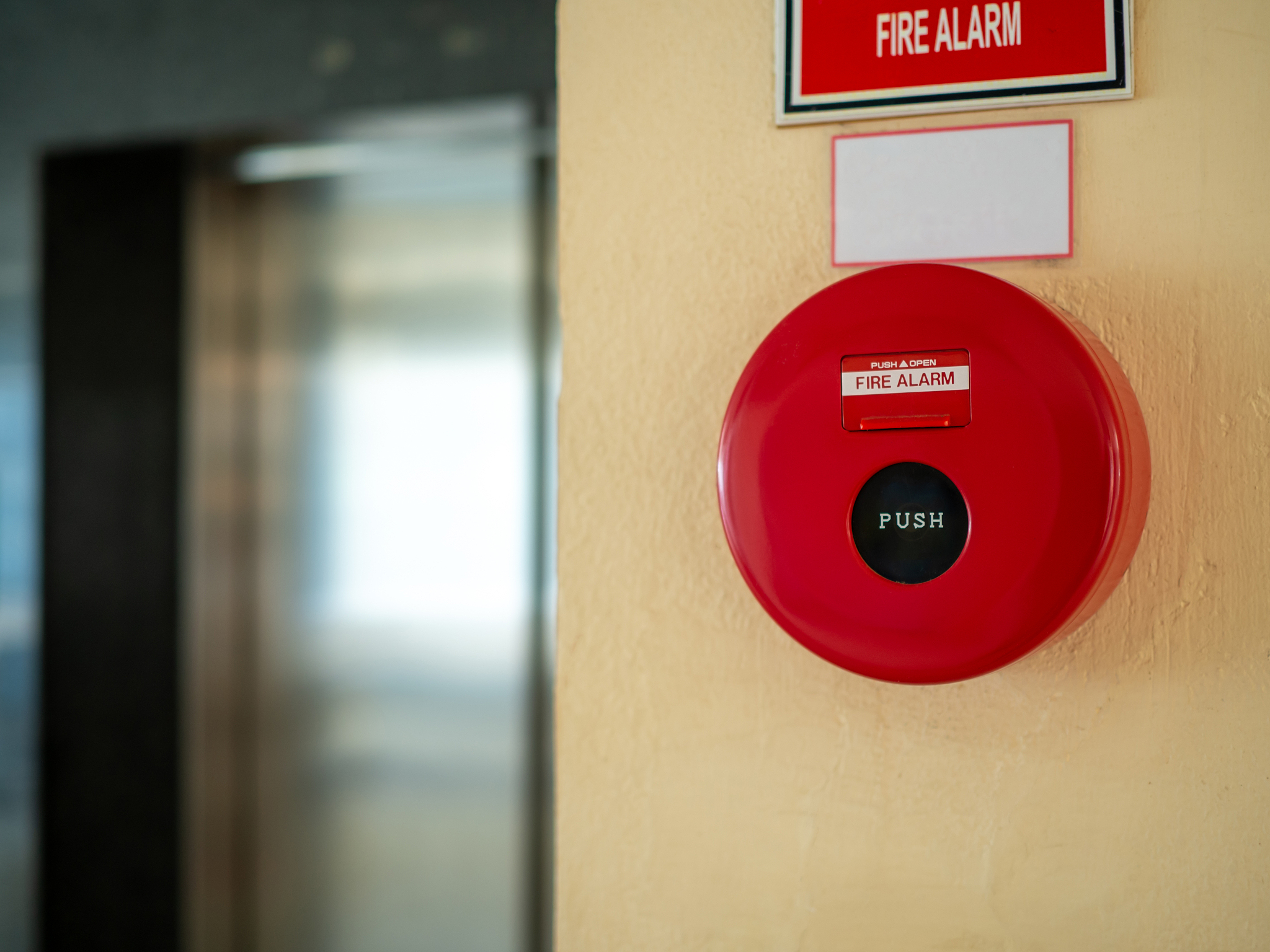 a circular fire alarm hung on the wall in a hospital.