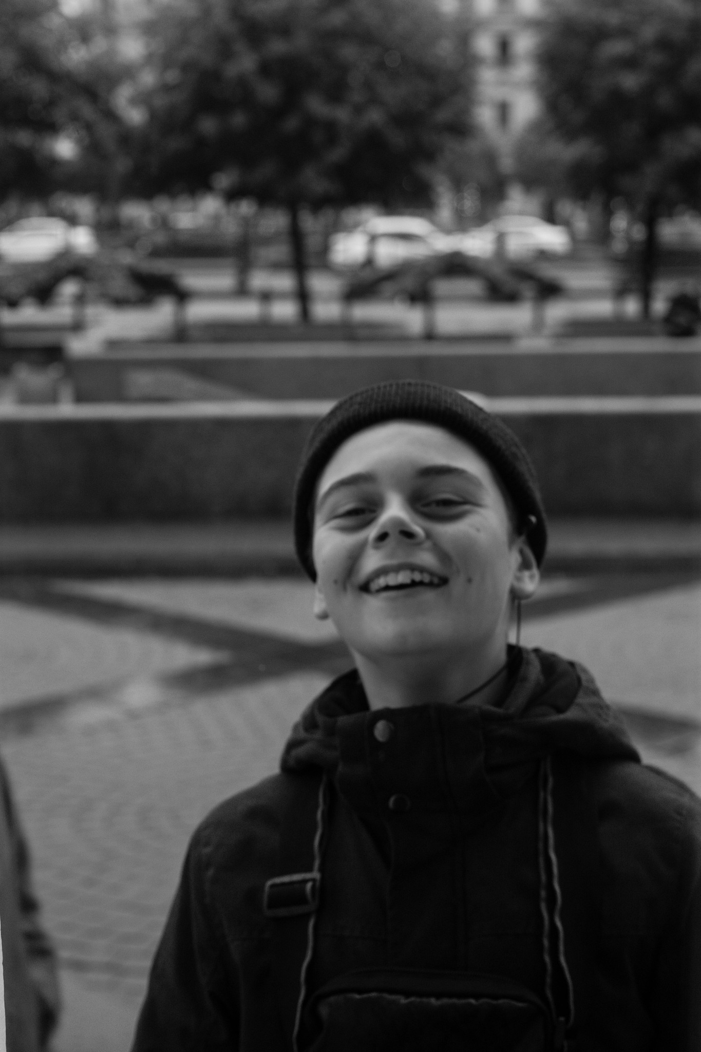 portrait of smiling man standing on footpath in city