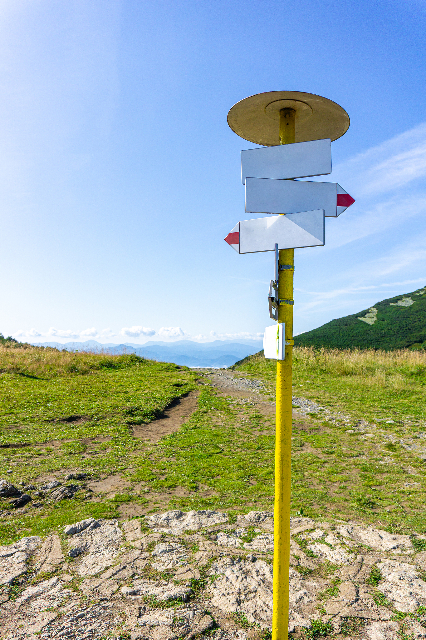 blank signpost on a sunny day with a road in the mountains, beau