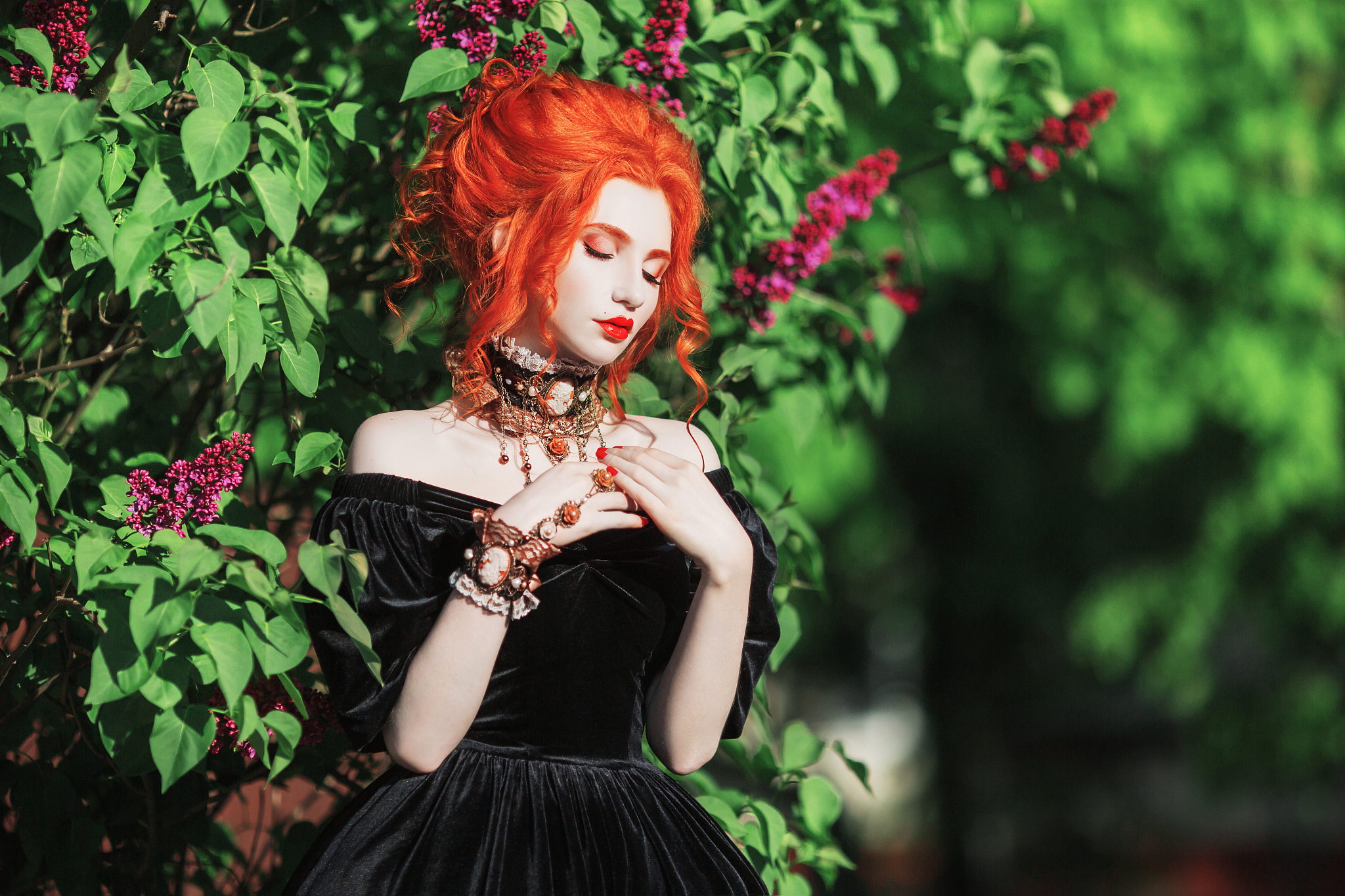 dark halloween attire. goth woman with pale skin and red hair in