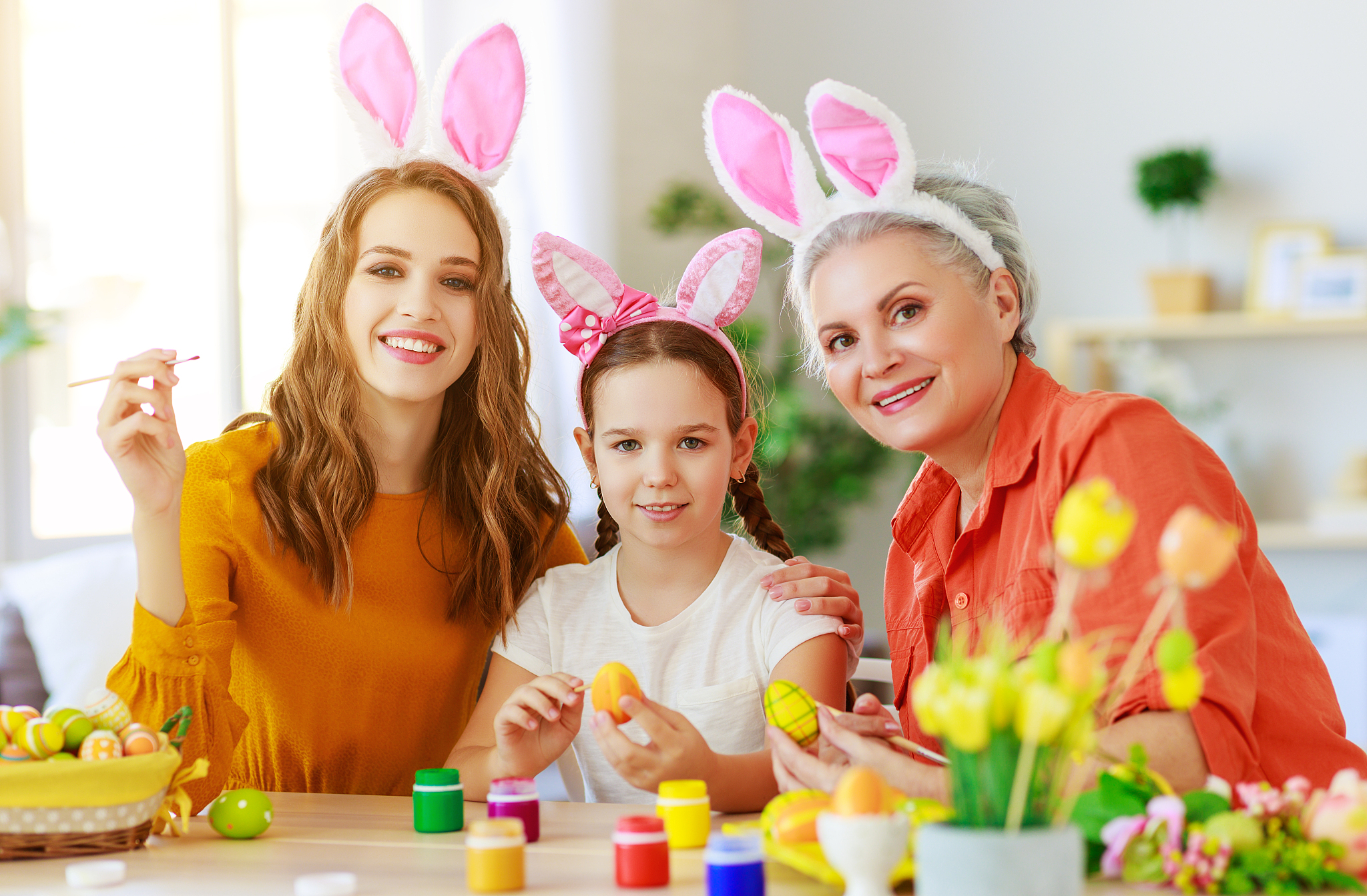 happy easter! family grandmother, mother and child paint eggs an