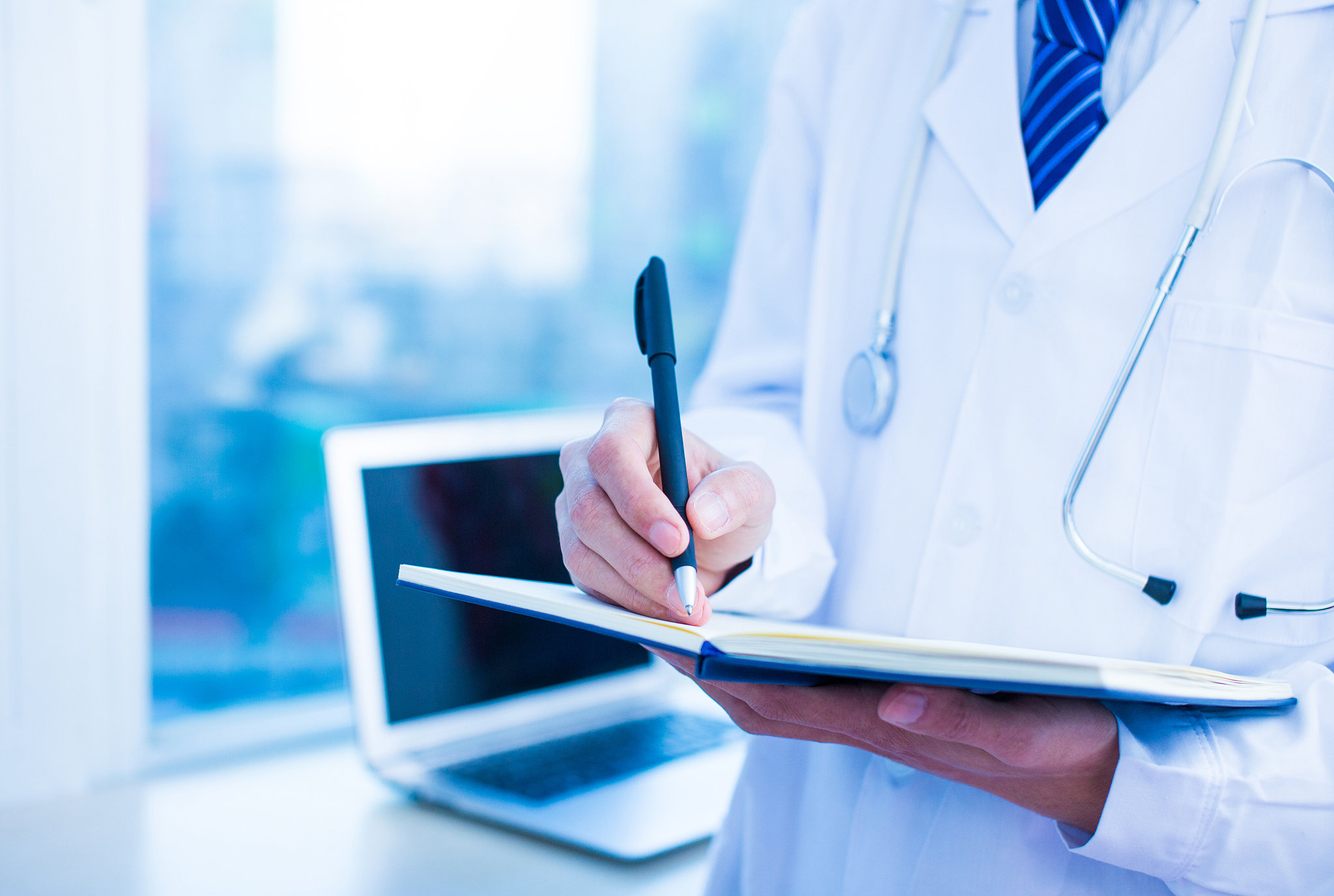 doctor writing on notebook