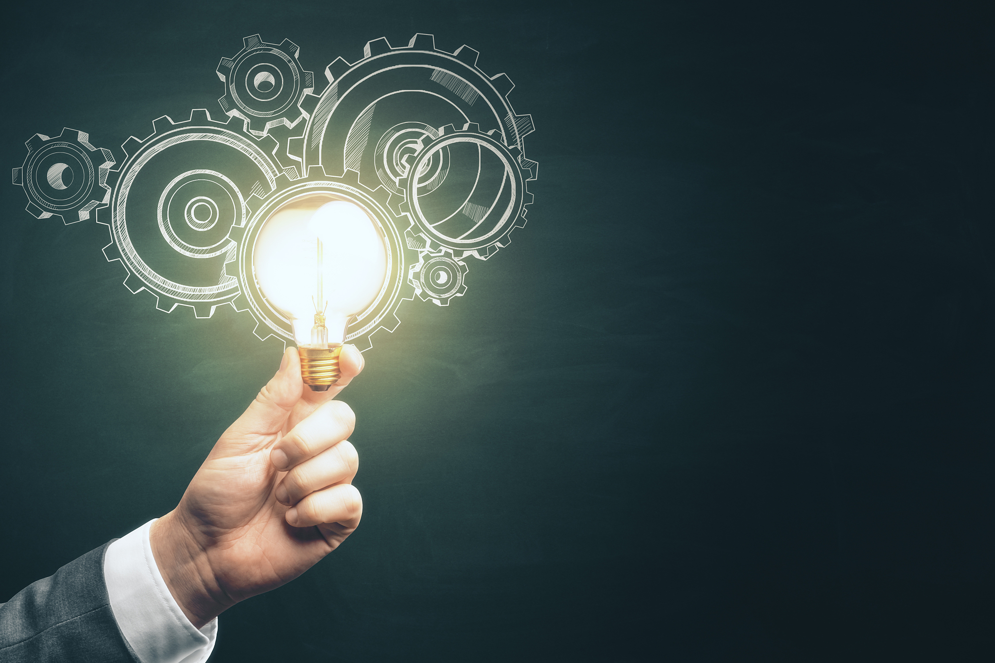 businessman hand holding light bulb with gears