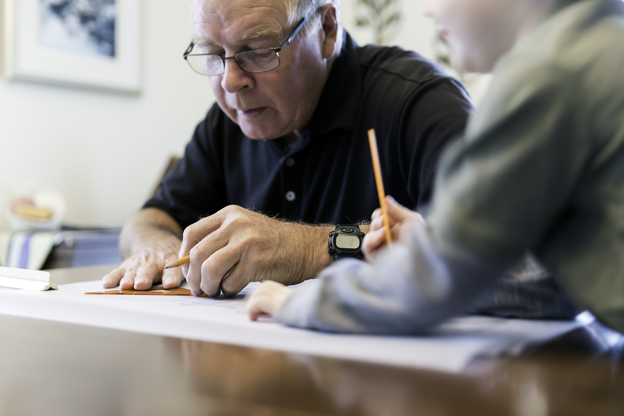 grandfather drawing and looking at home plan design with grandso