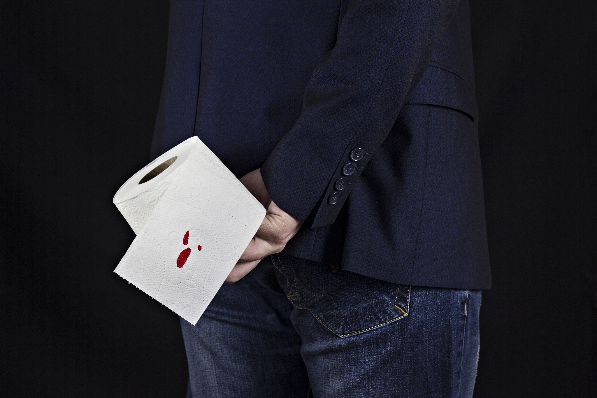 man in suit holds toilet paper with blood, hemorrhoids, black ba