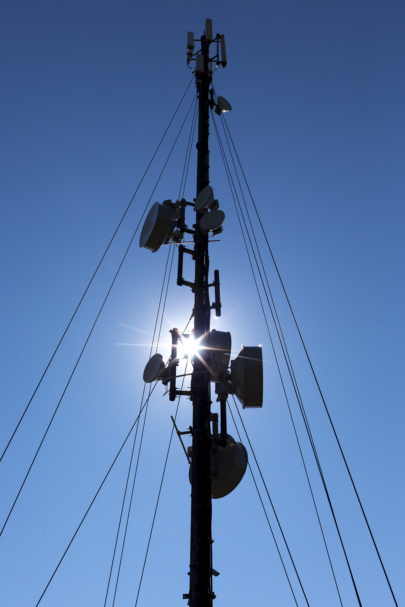 communication tower silhouette against blue sky