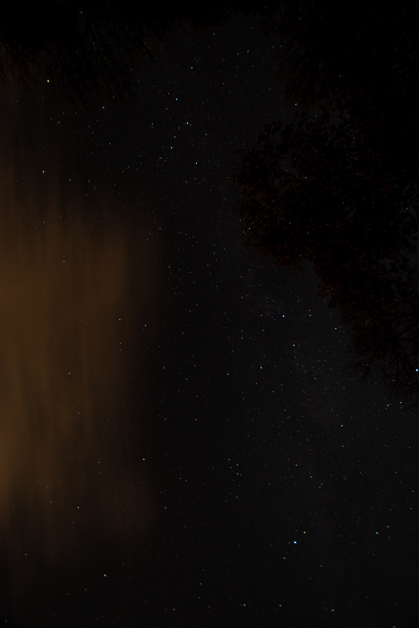 a night sky full of stars and orange clouds