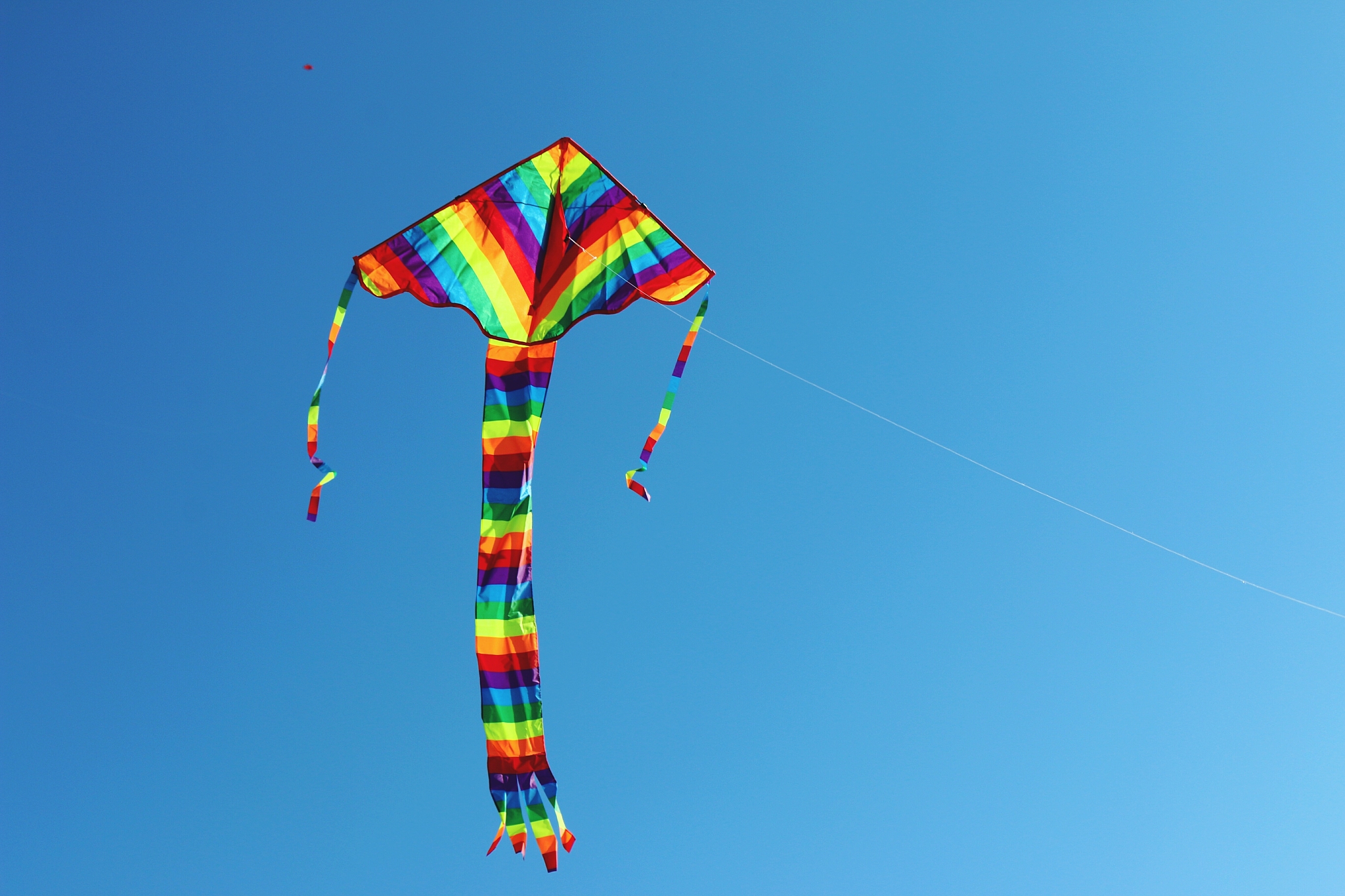 low angle view of multi colored kite in clear blue sky