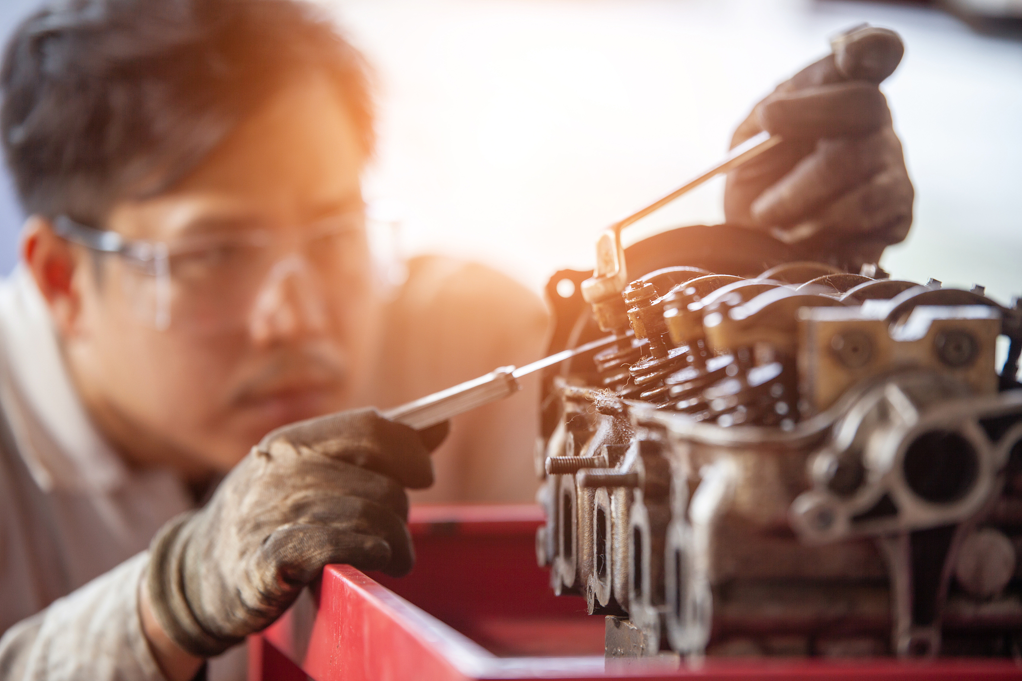 mechanic with a tool in his hands repairing the motor of the mac