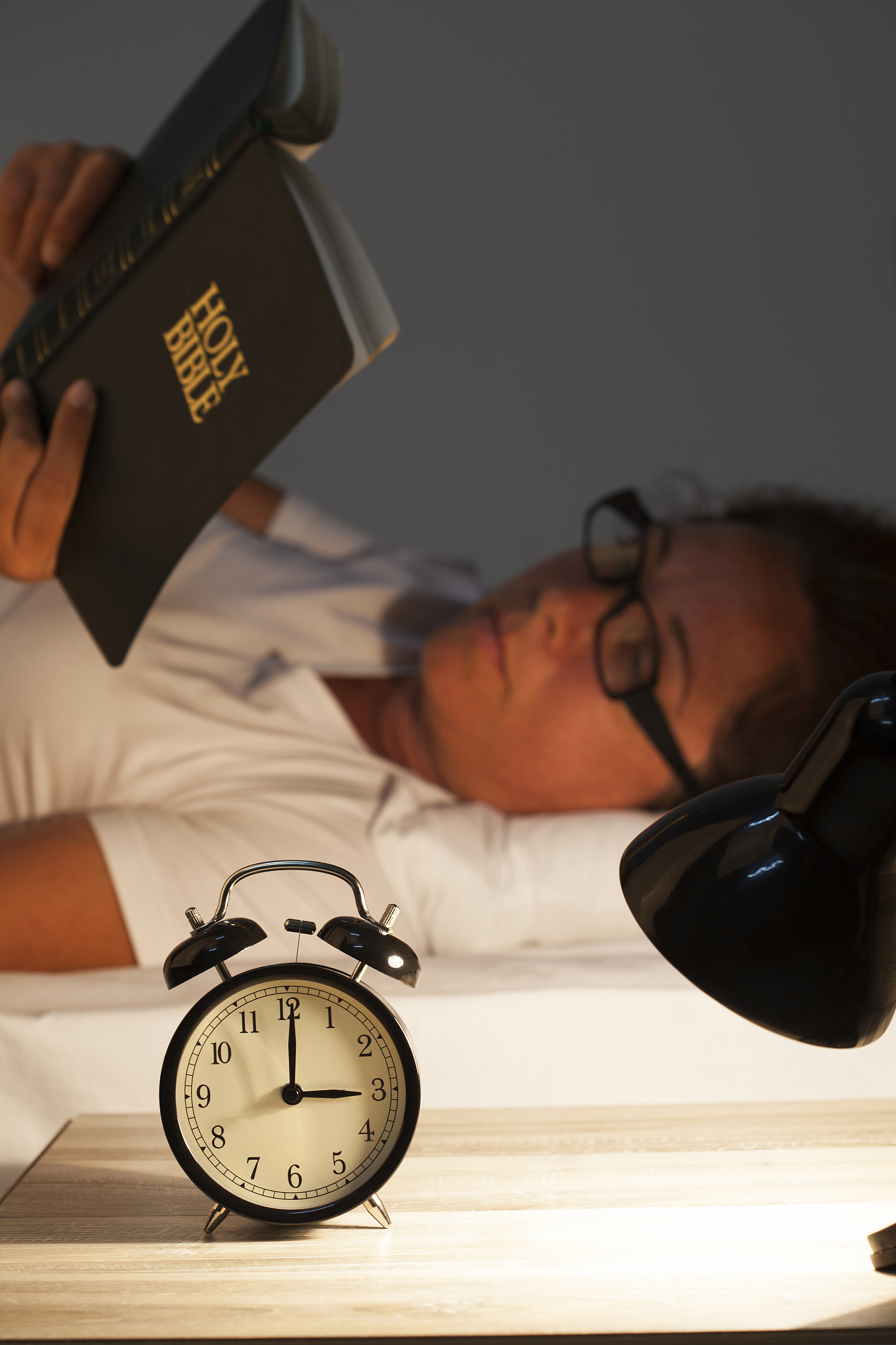 woman lying in bed and reading  bible