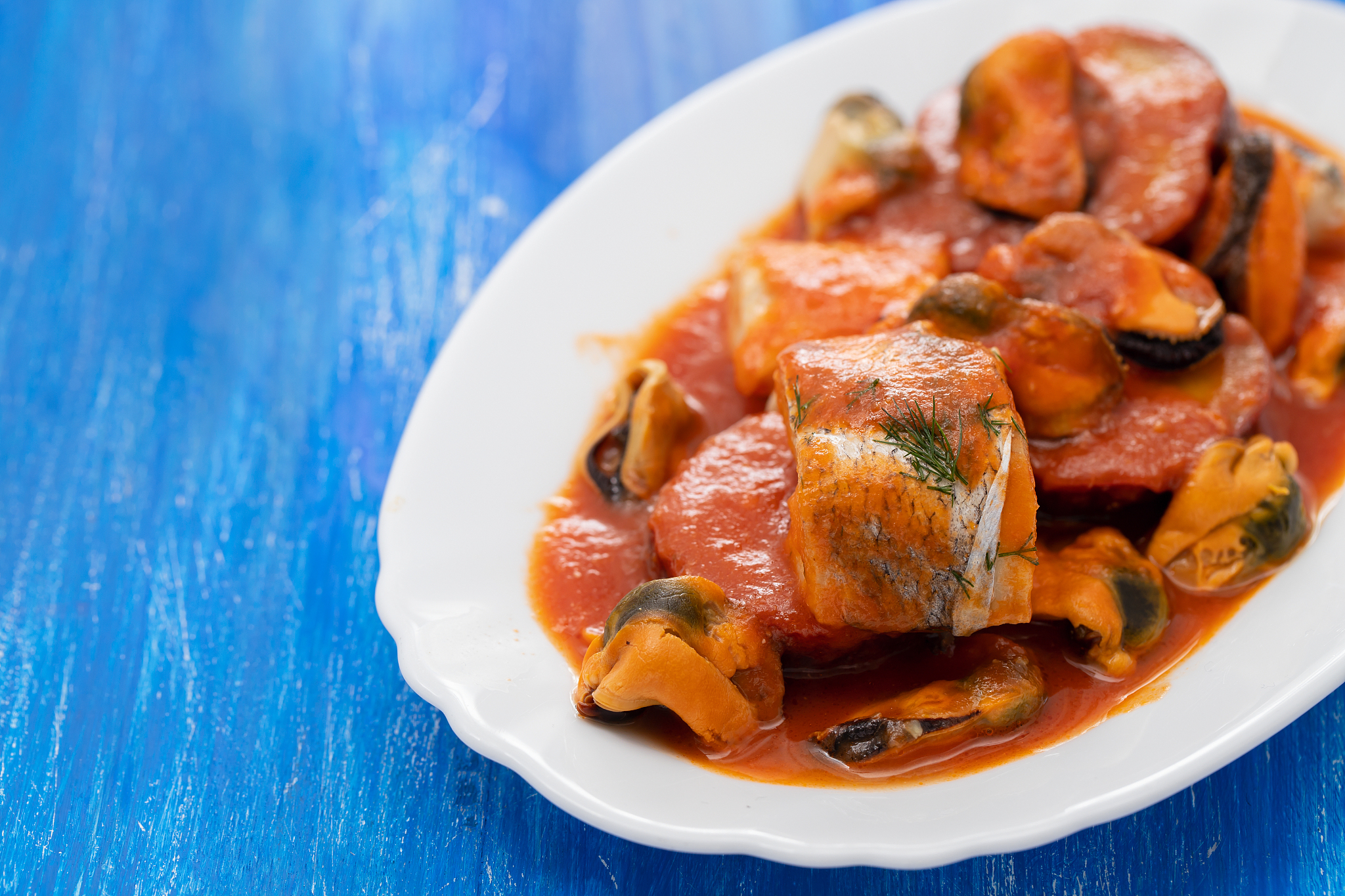 fish with seafood and sweet potato on white dish