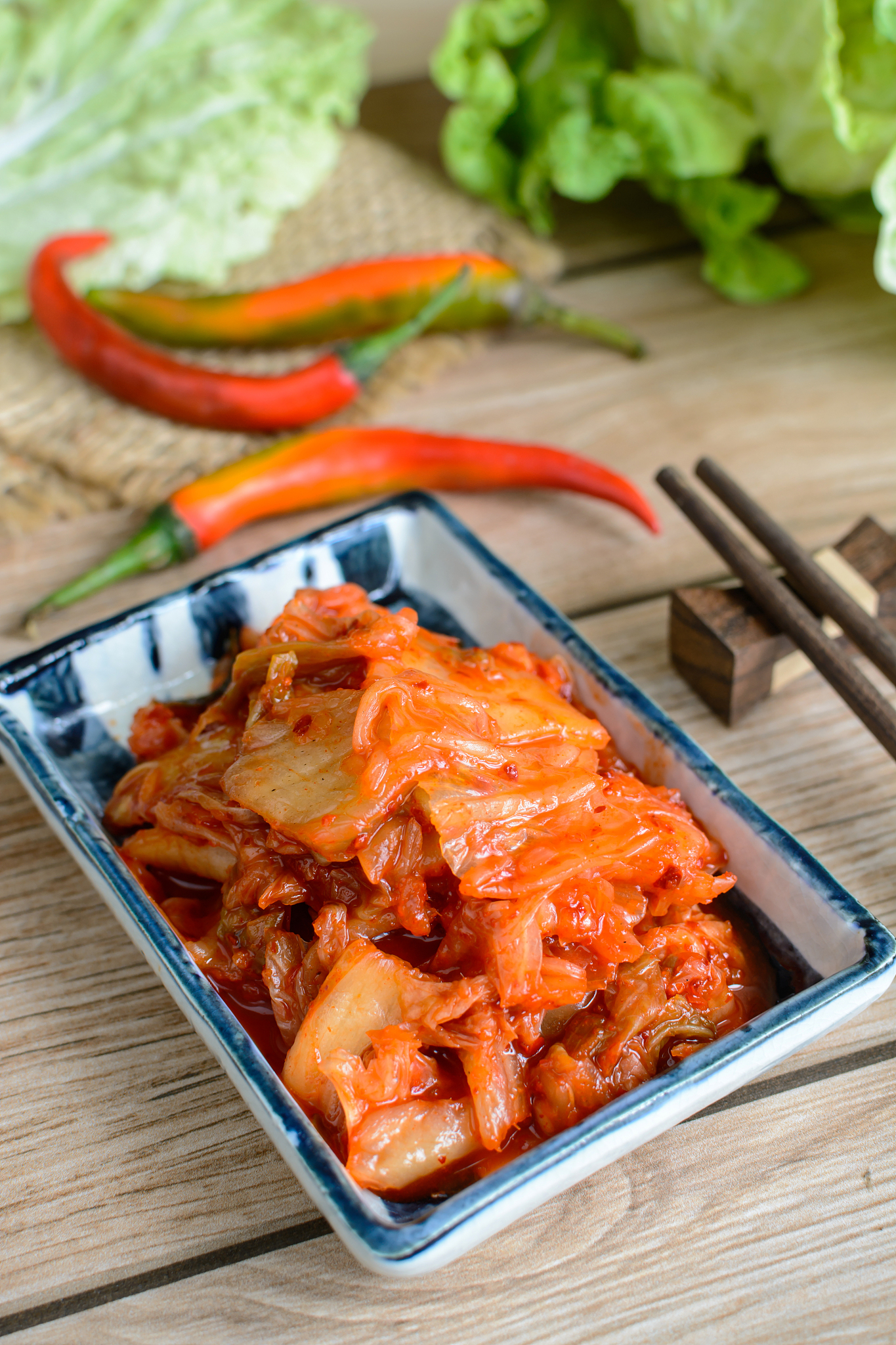 kimchi with chopsticks on wooden table, korean traditional food