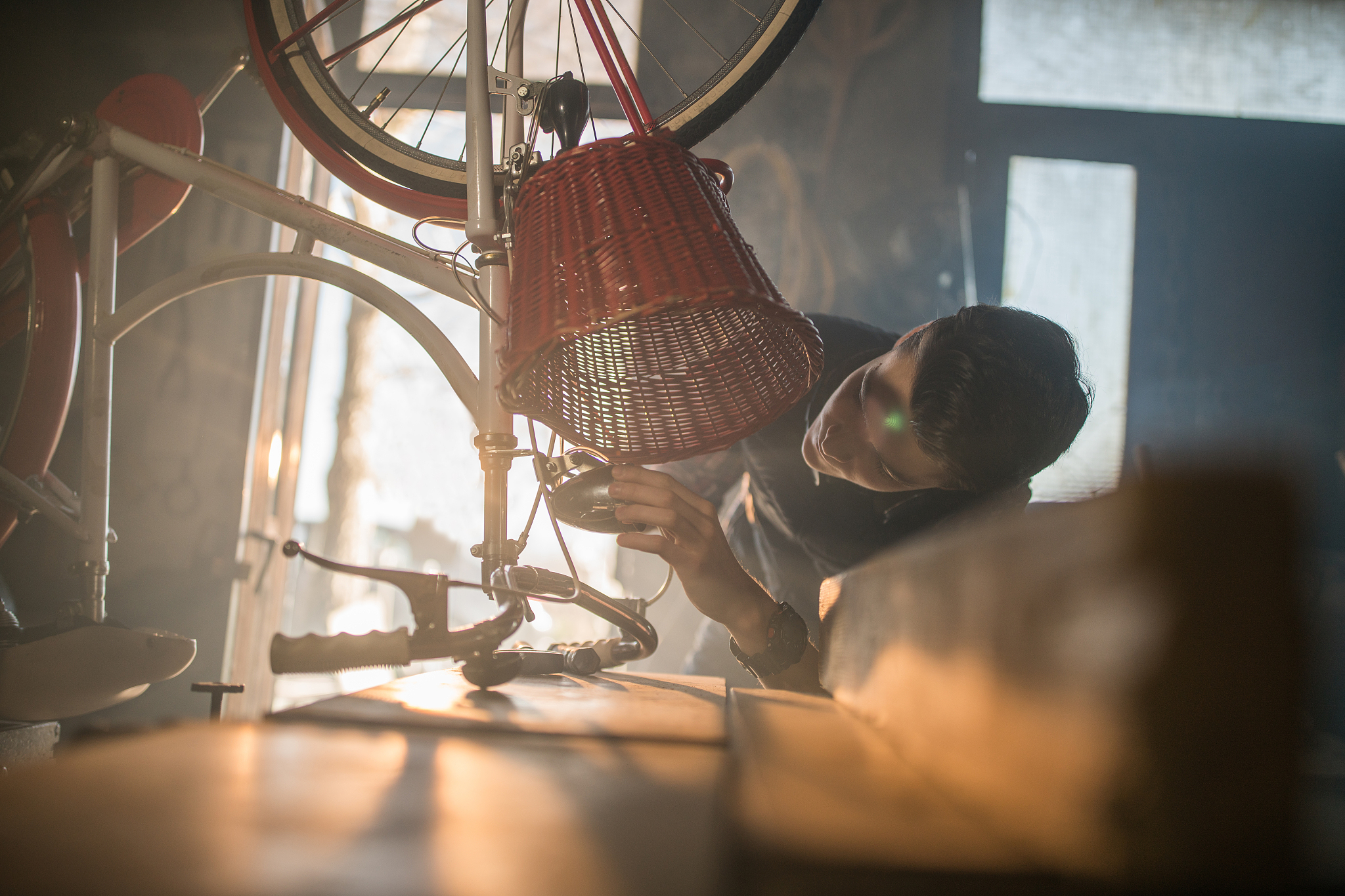 man repairing bicycle in workshop