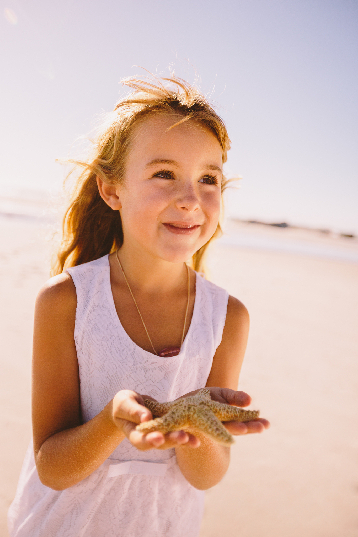 girl holding starfish in hands