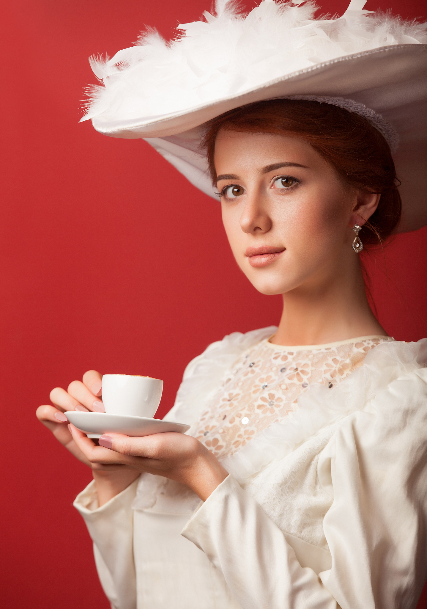 portrait of redhead edvardian women with cup on red background.