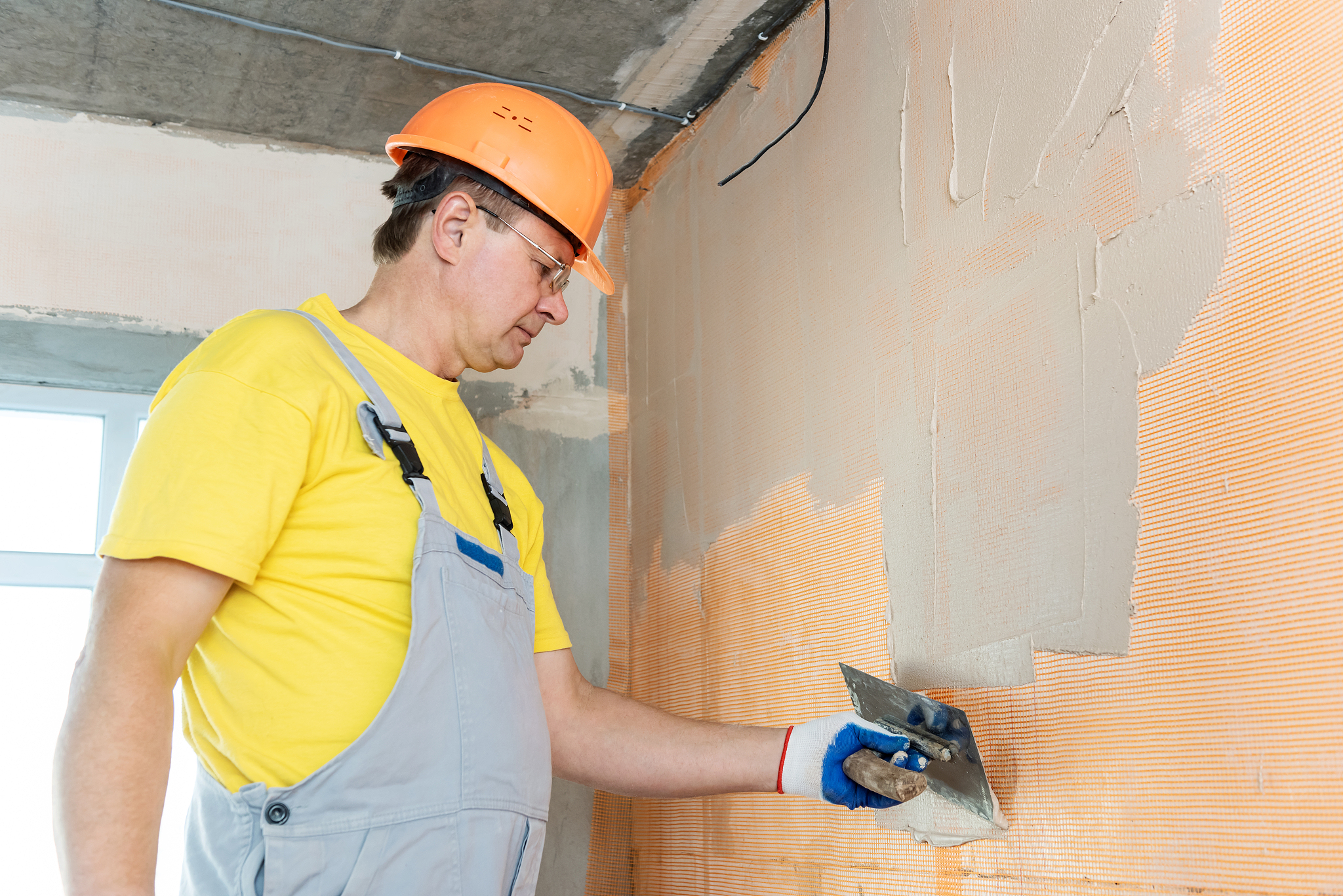 the construction worker putty a wall.
