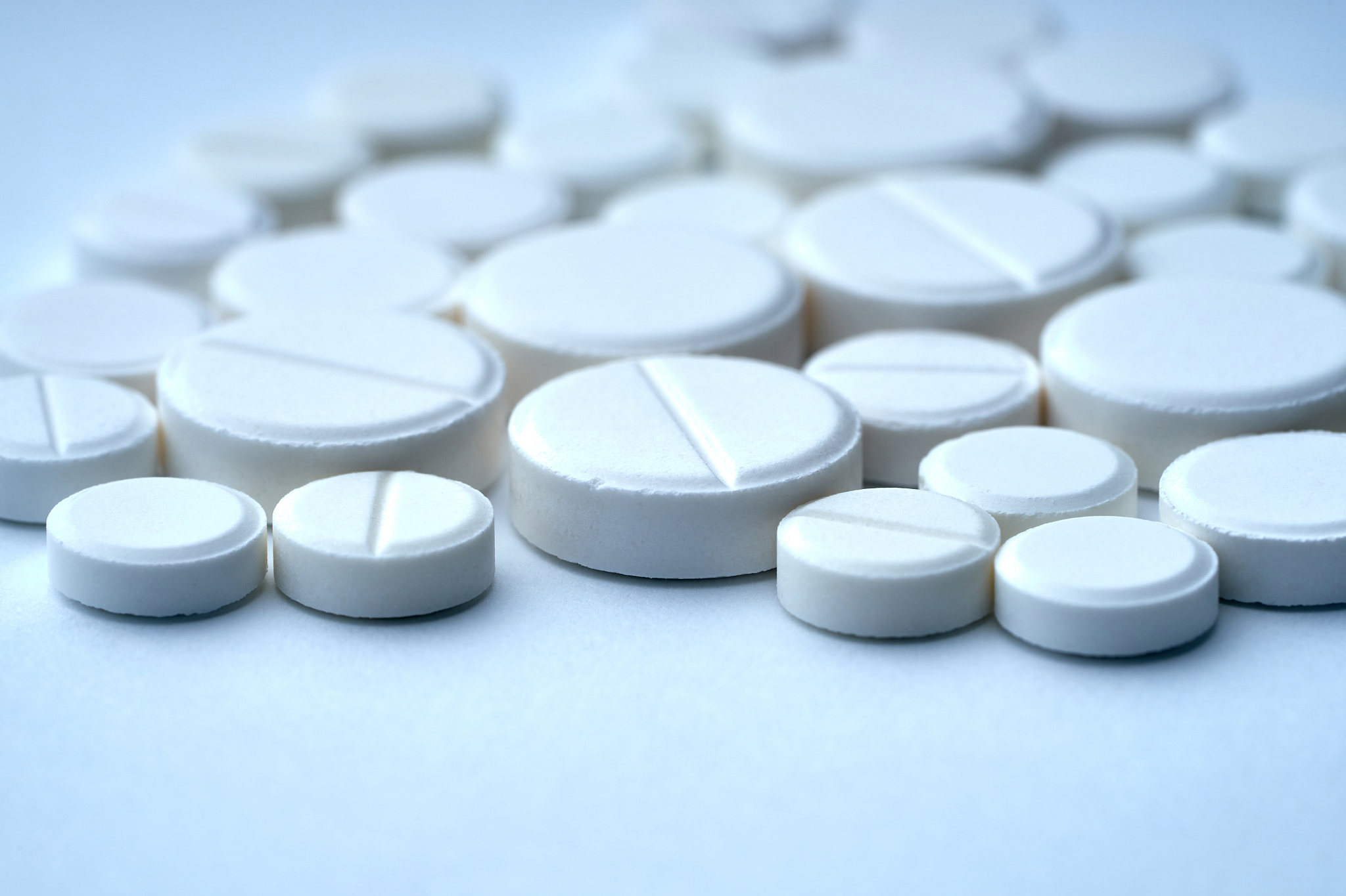closeup of white pills on a white background with texture.