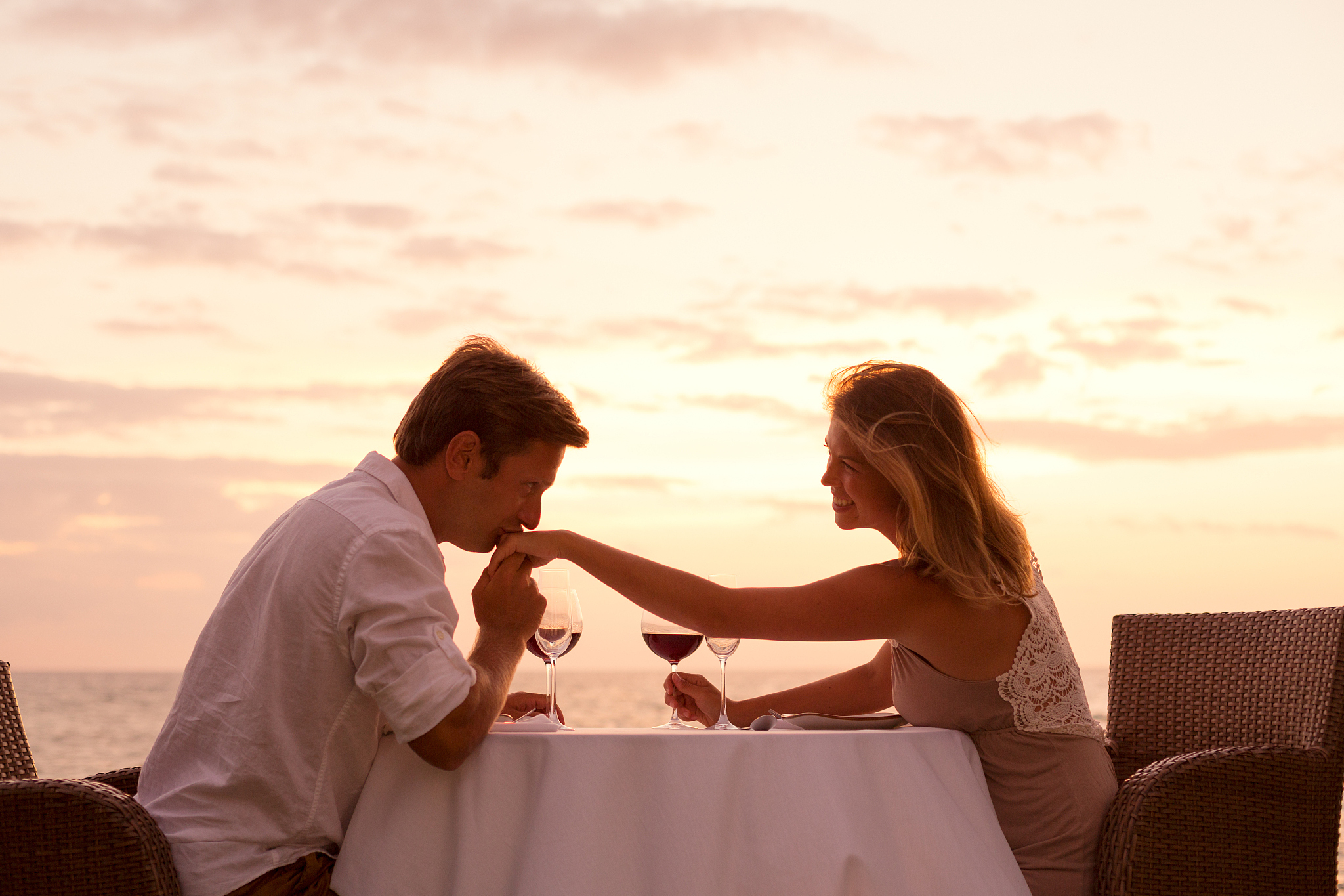couple enjoying romantic sunnset dinner on the beach