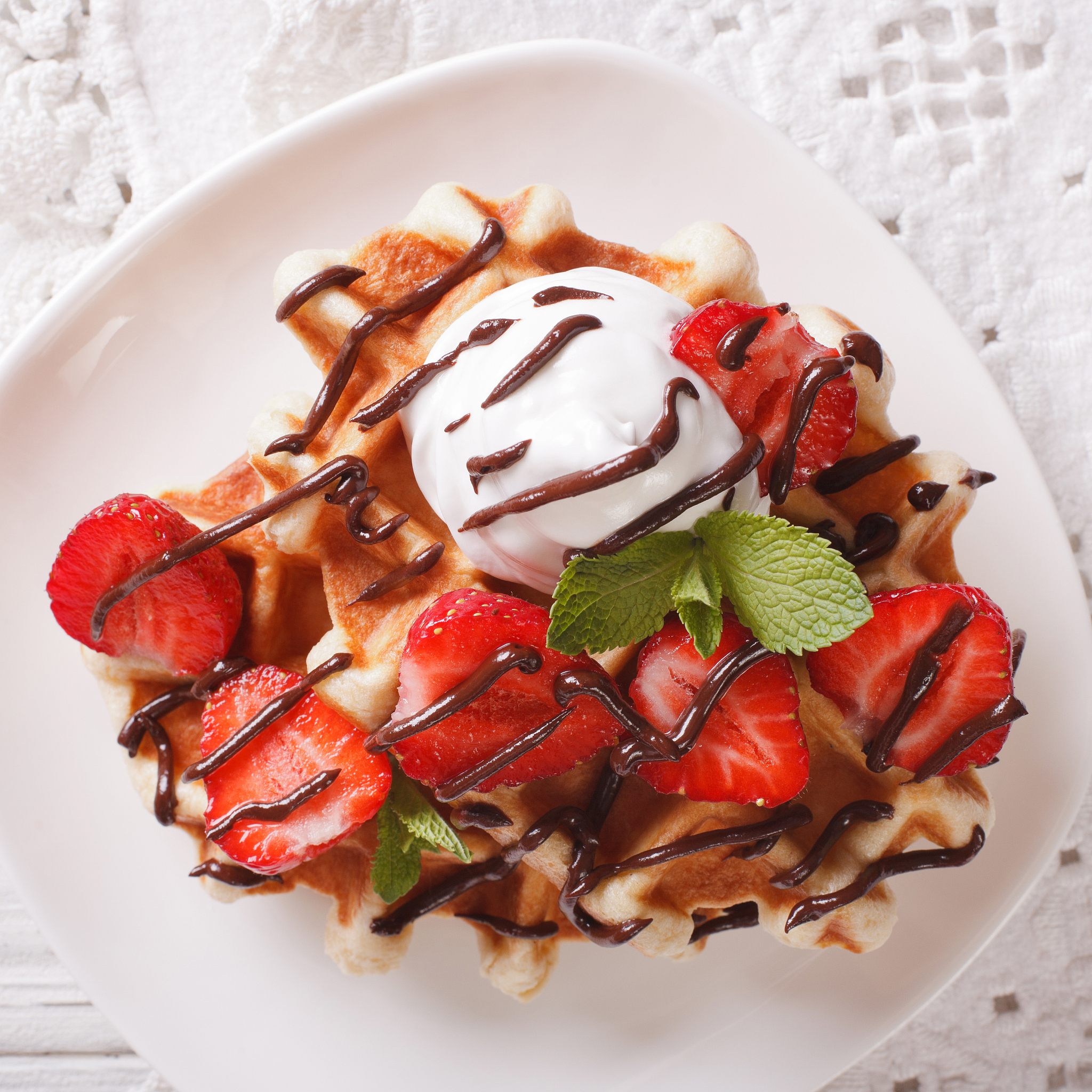 waffles with strawberries, whipped cream and chocolate closeup.