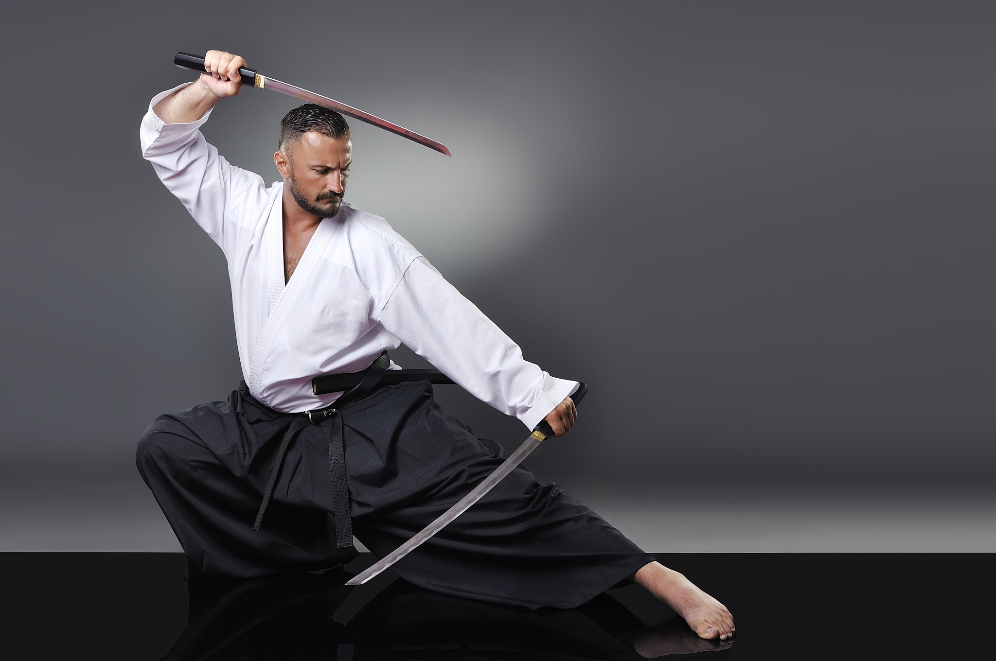 handsome young black belt male karate posing with swords