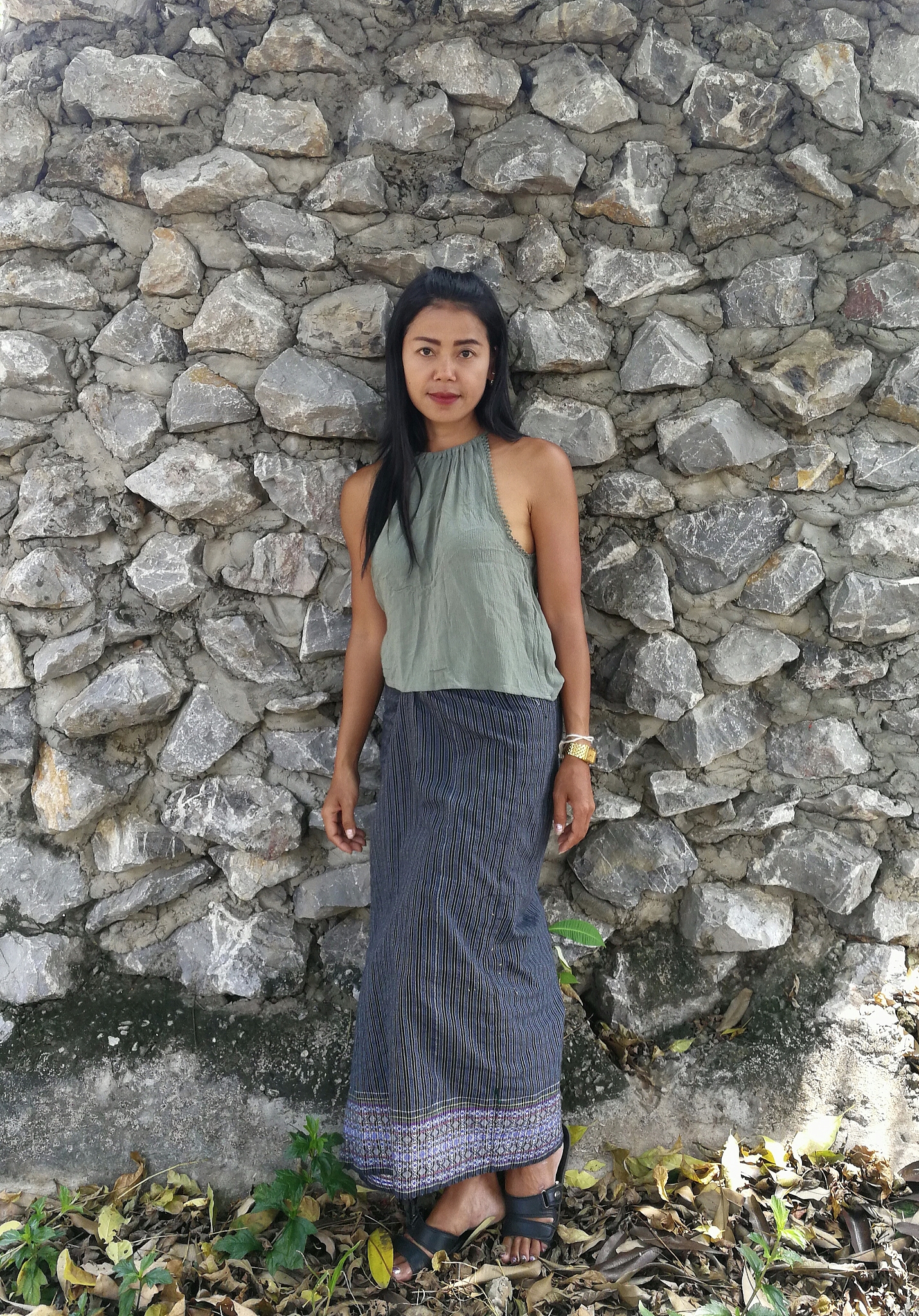 portrait of woman standing against stone wall