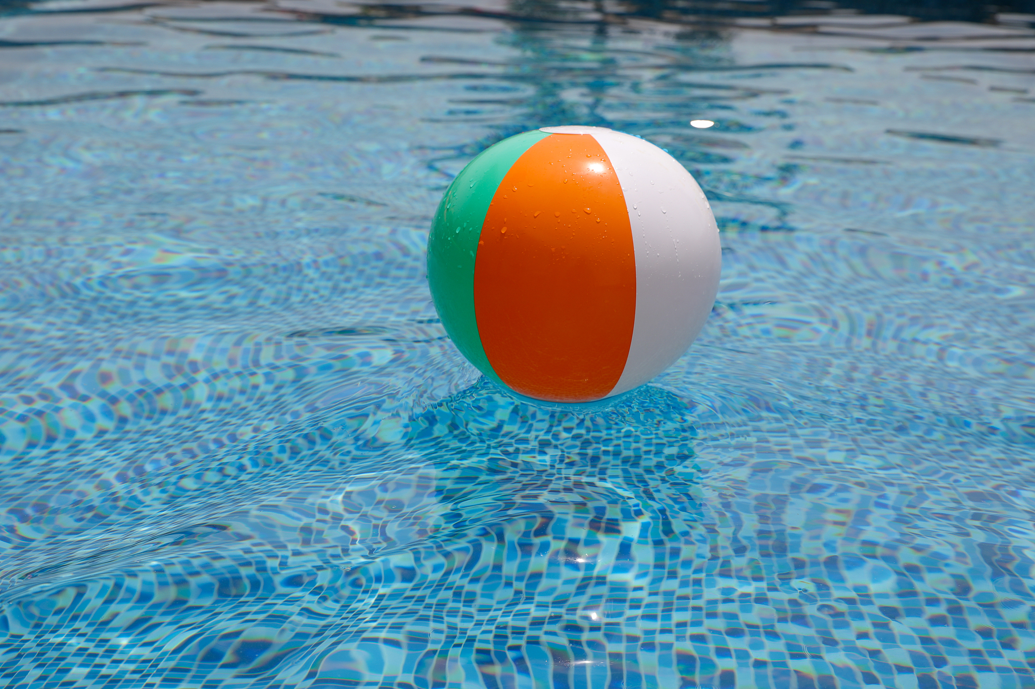 beach ball in pool. colorful inflatable ball floating in swimmin