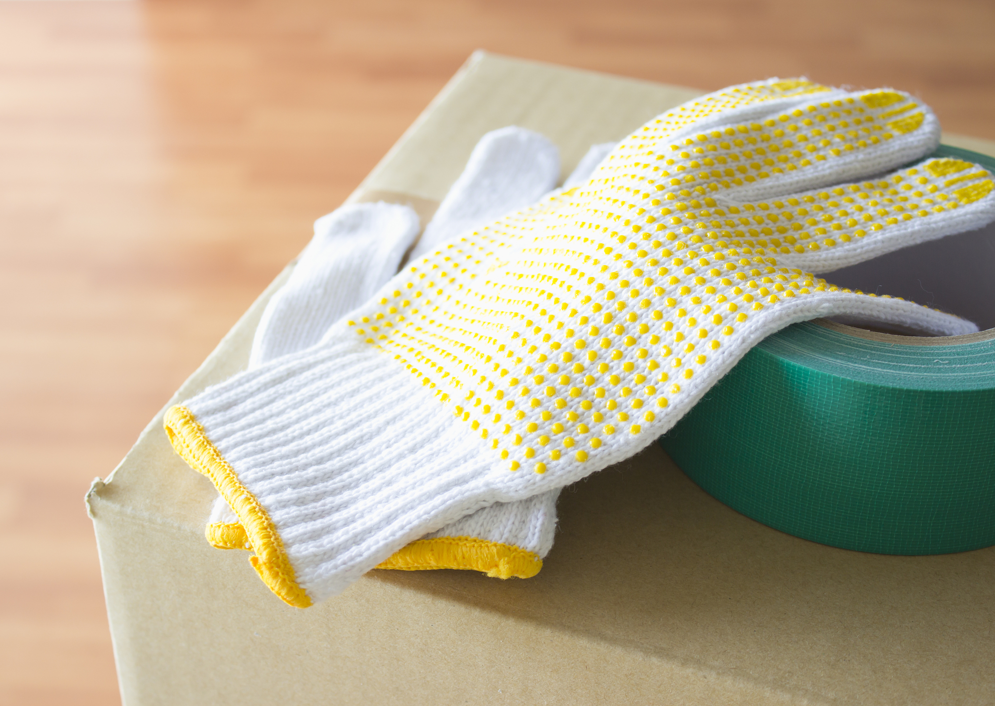 work gloves and a packing tape on a cardboard box