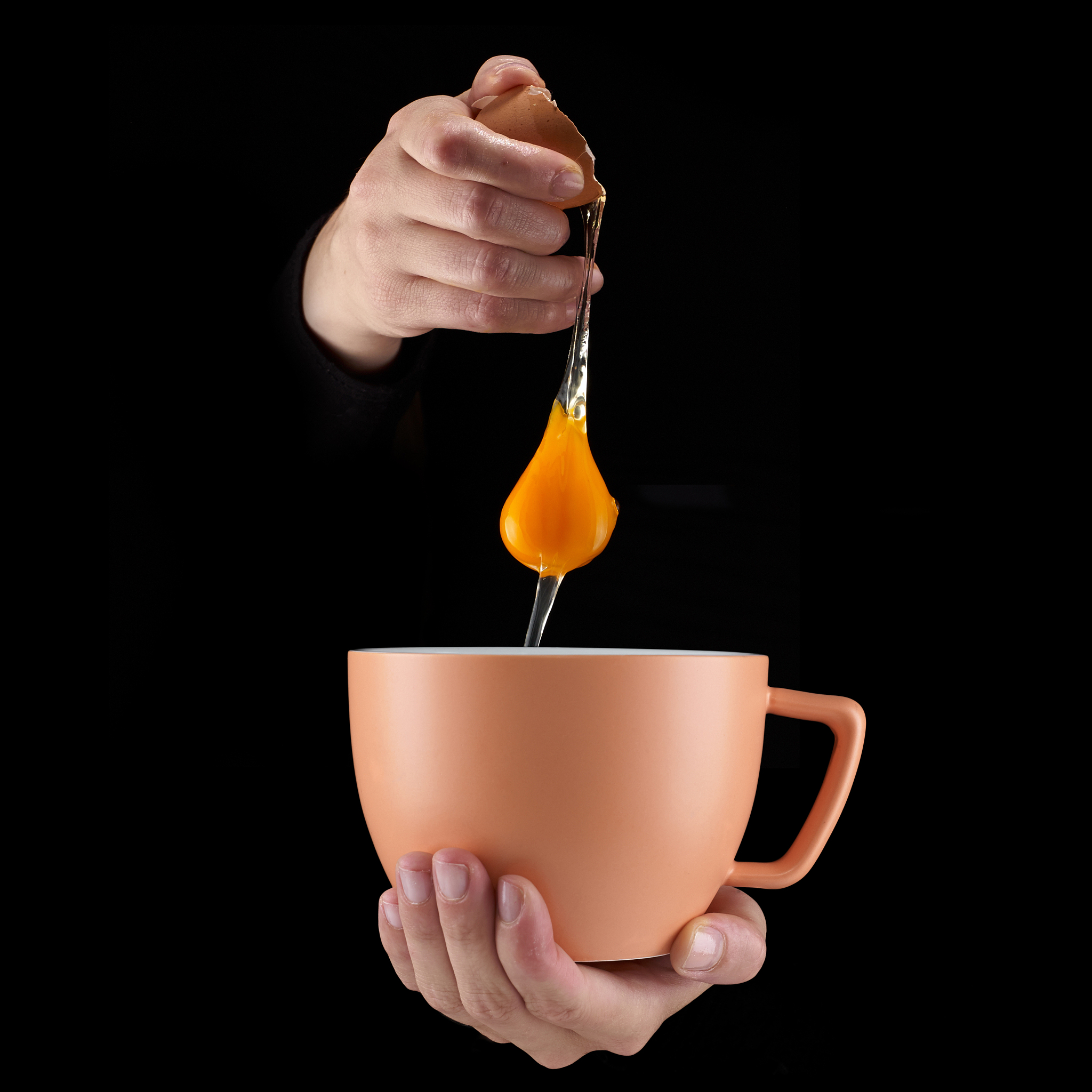 egg yolk dripping in to cup.