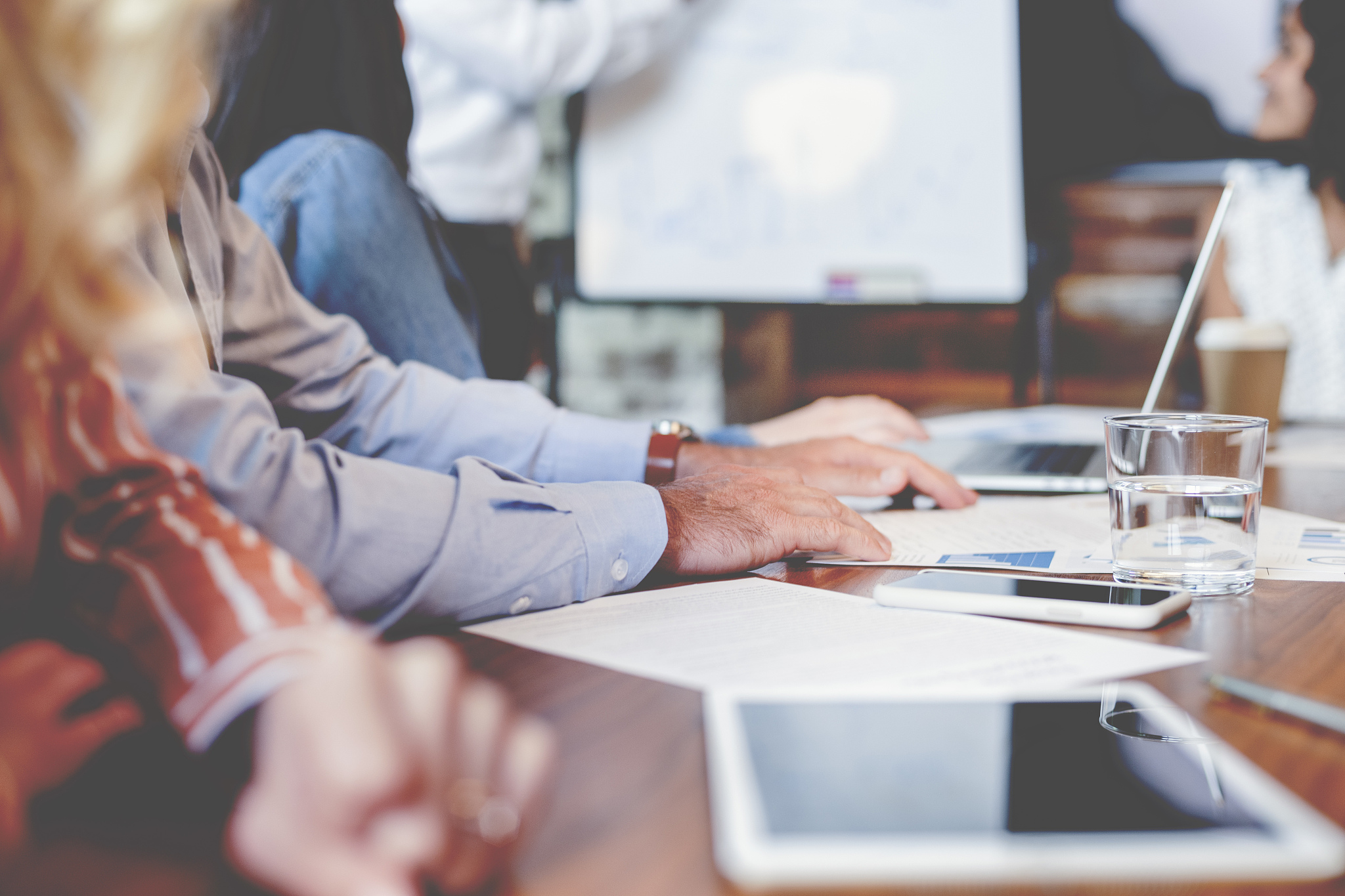 close up of hands on a board room table at a business presentati