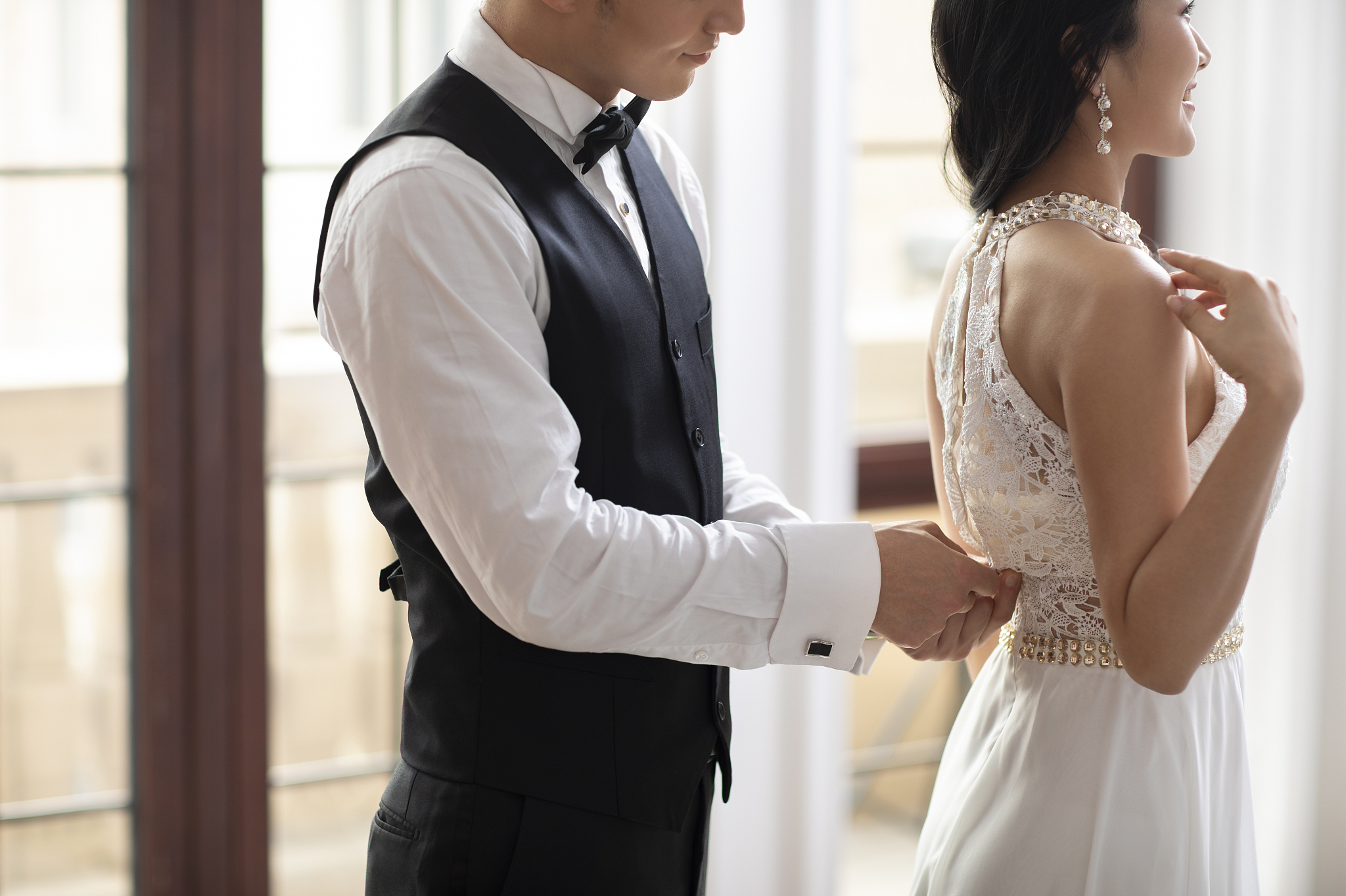 年轻男士帮妻子拉裙子拉链