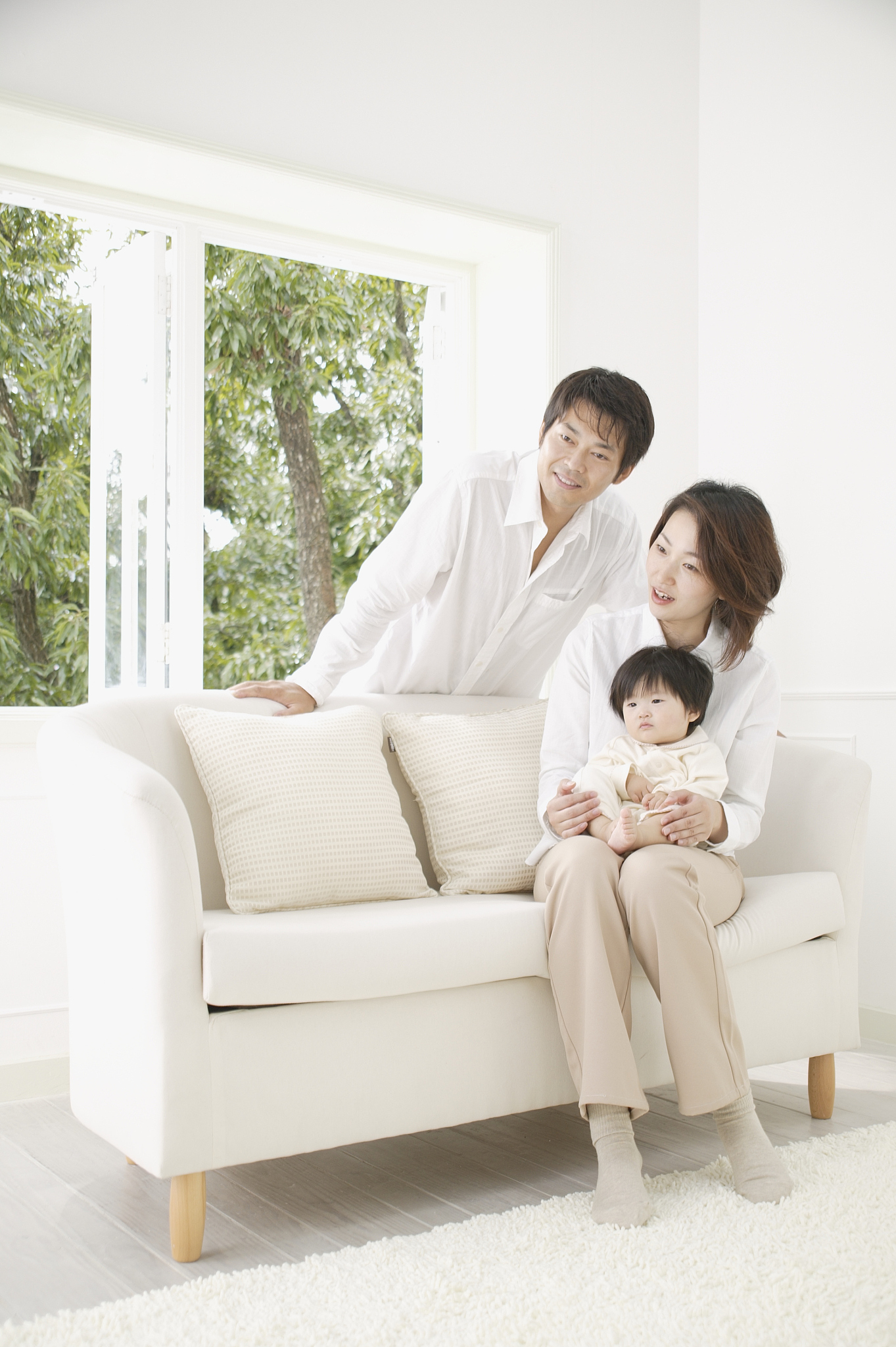 parents and a baby girl sitting on a sofa