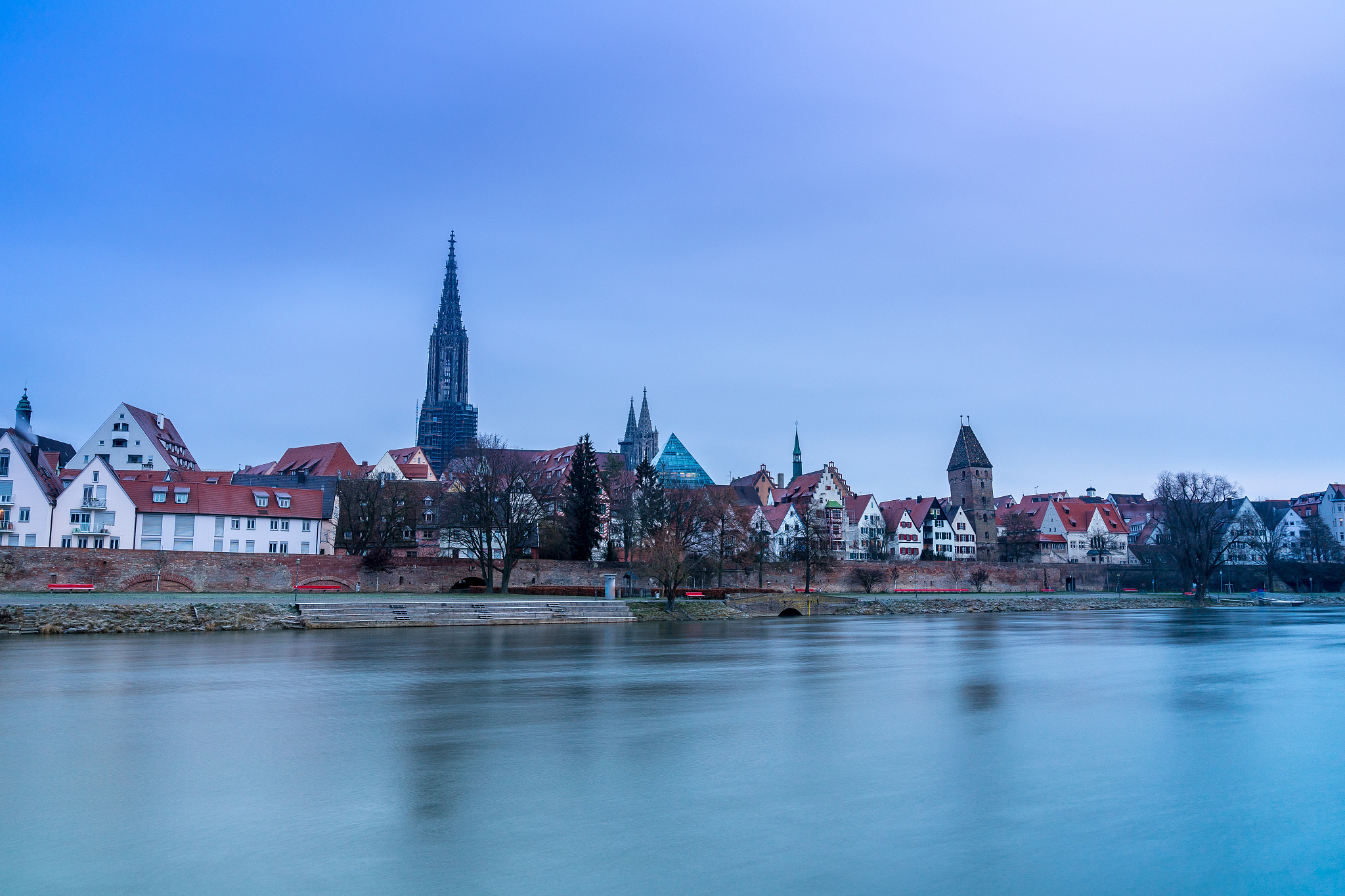 germany, skyline of ulm city and silent water of danube river