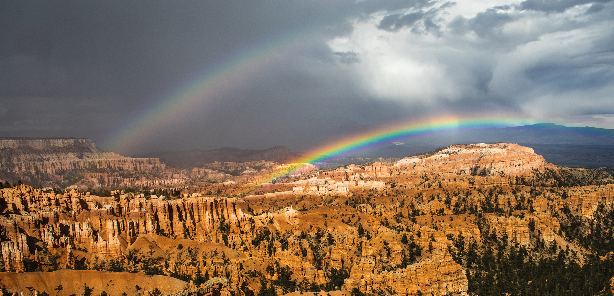 two rainbows above canyon