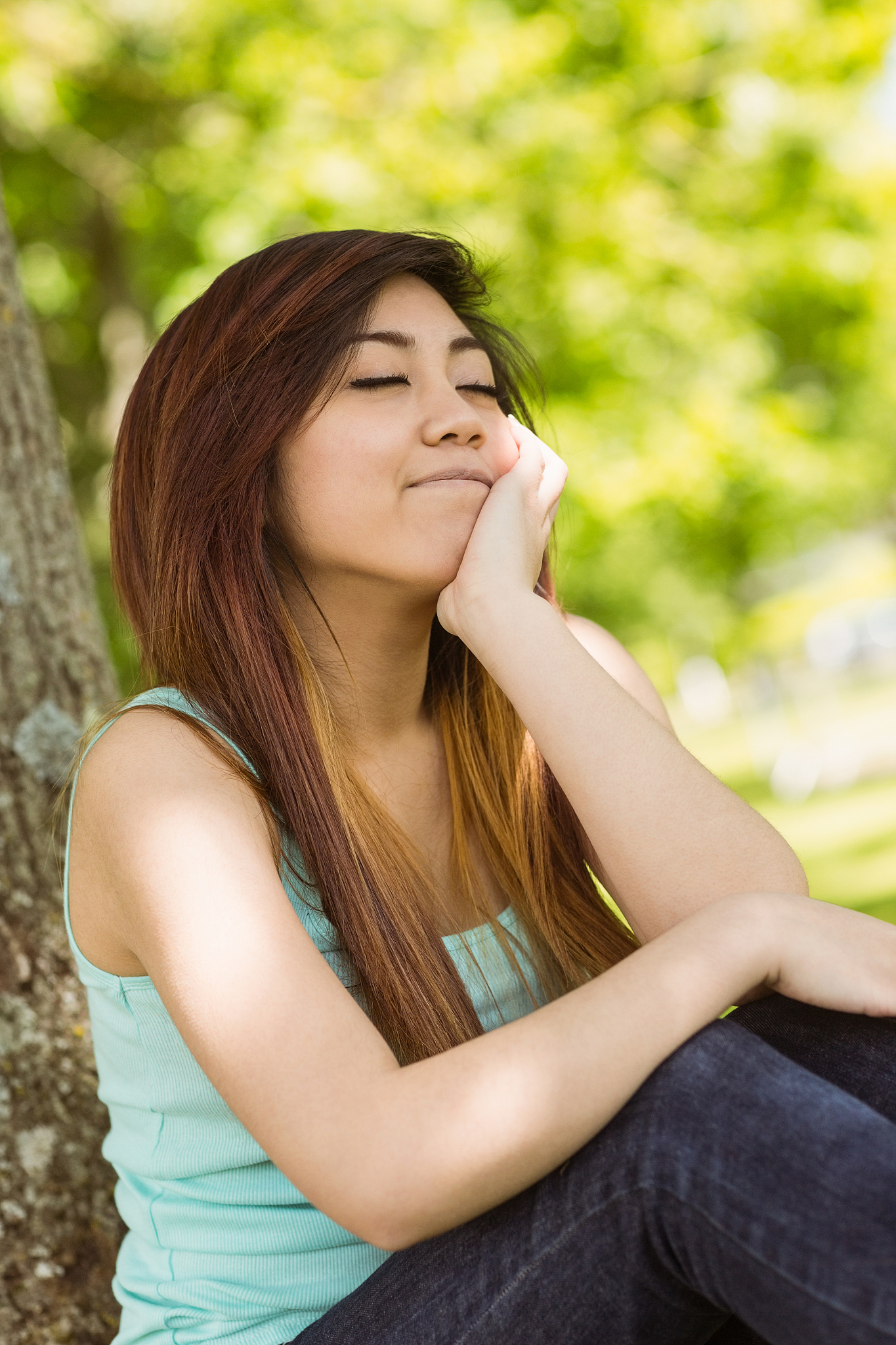 beautiful woman with eyes closed in park