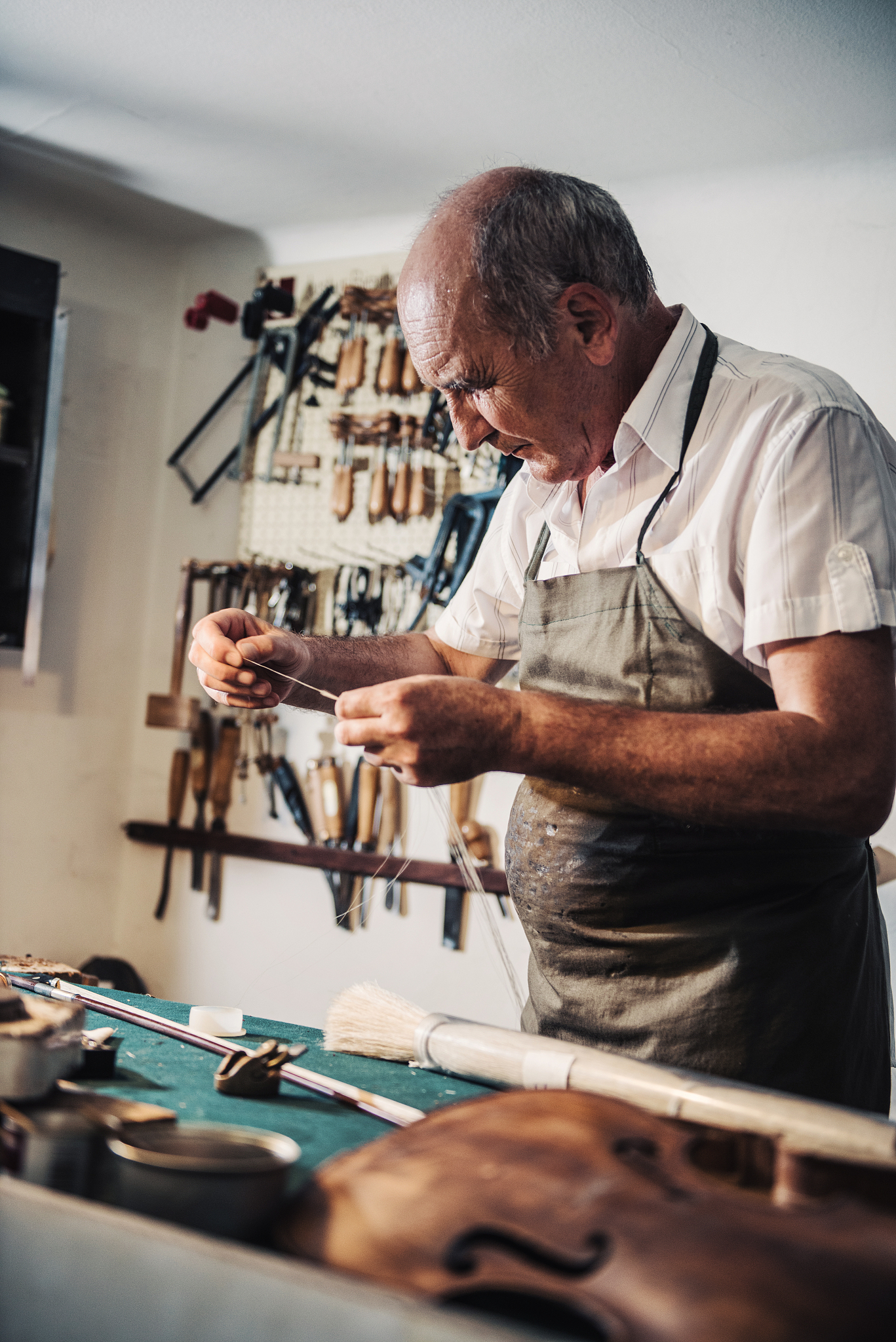 senior man working in music instrument shop