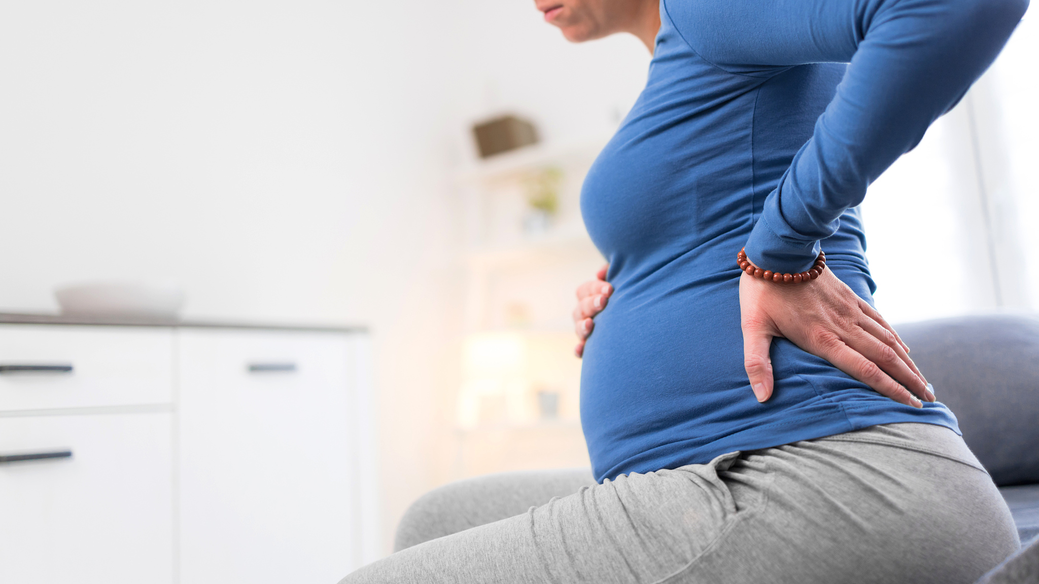 pregnant tired exhausted woman with stomach issues and back pain