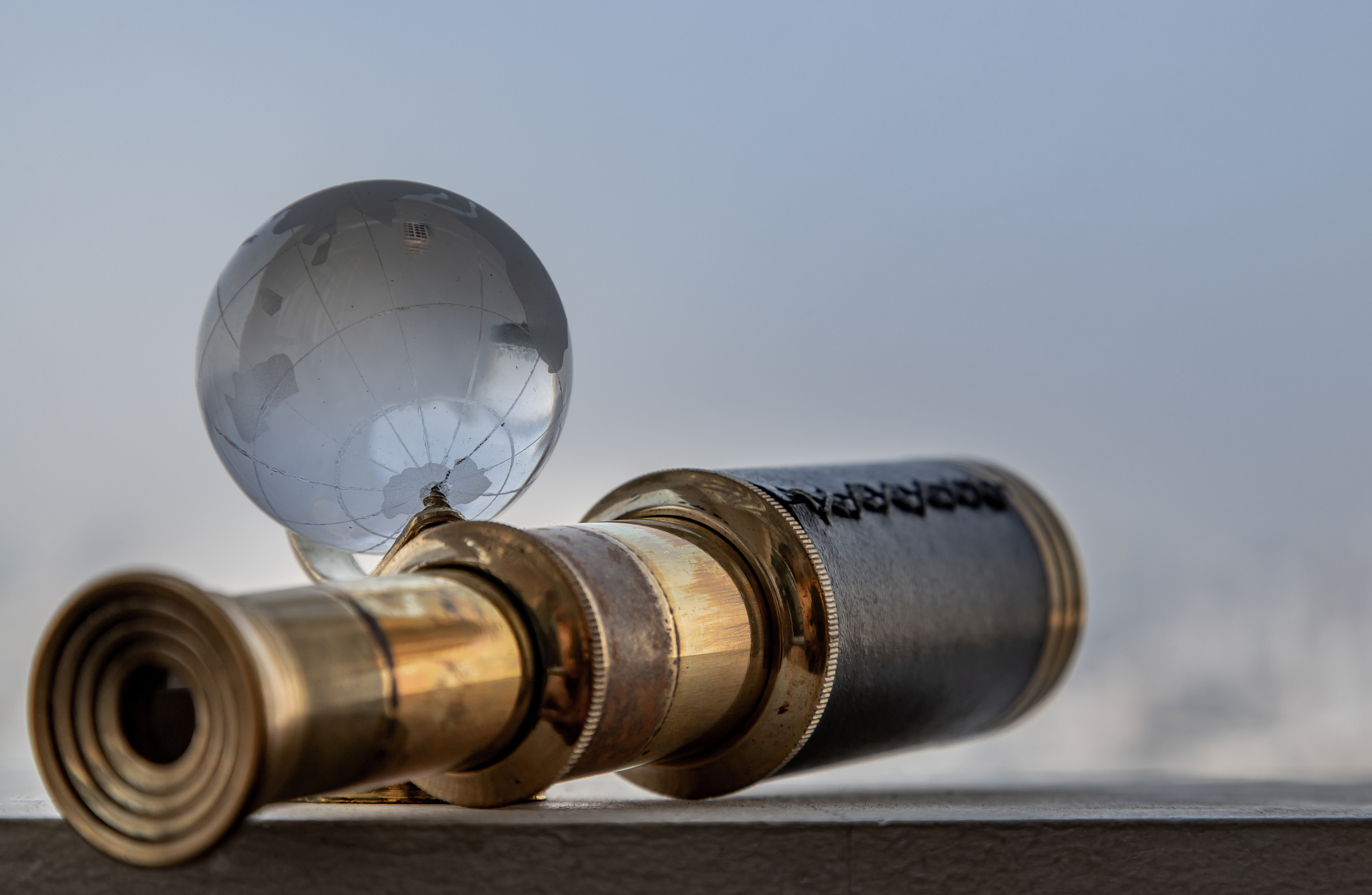 vintage binocular and crystal globe with sky background. travel 