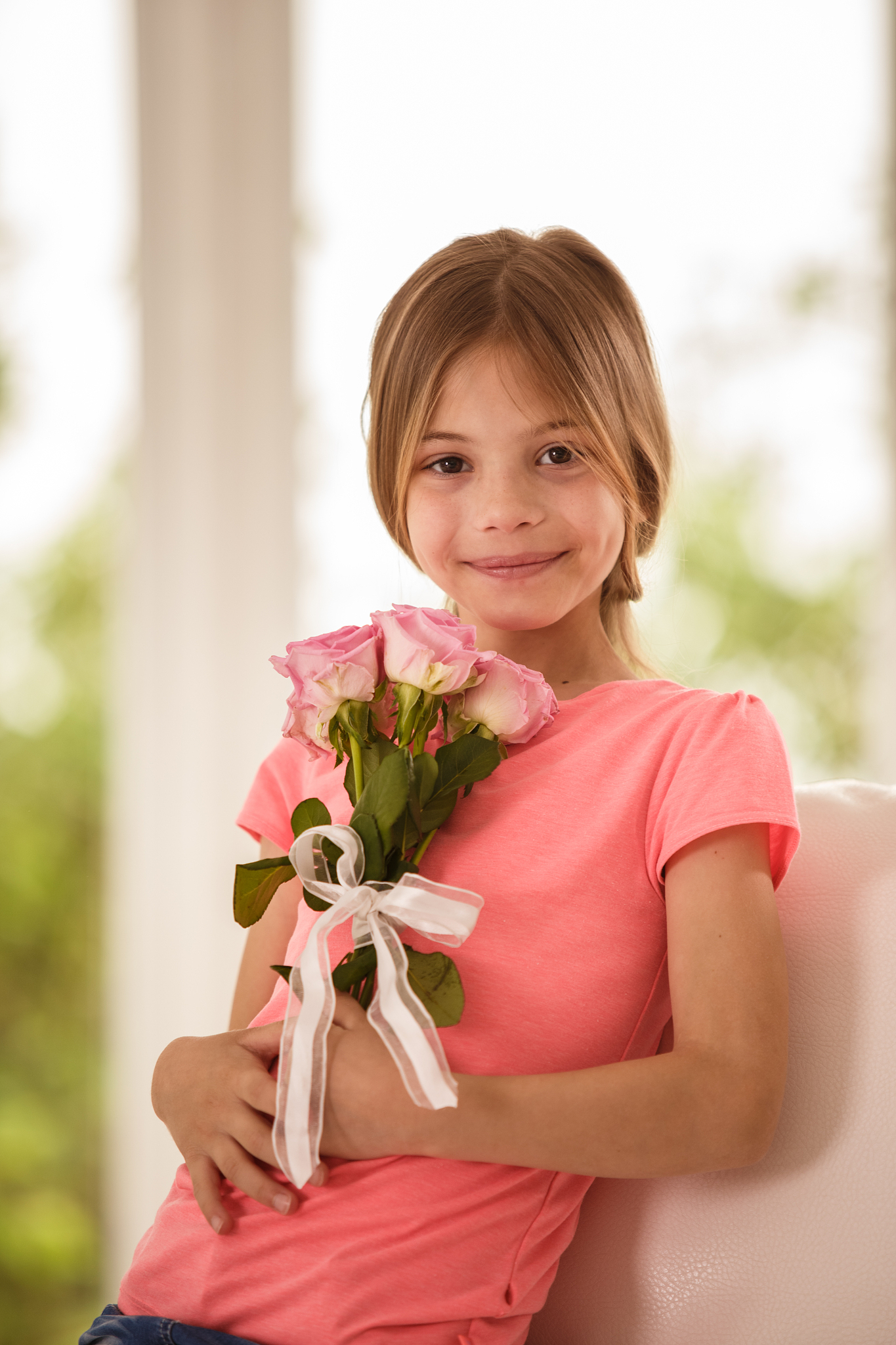 cute little girl with a bouquet of pink roses