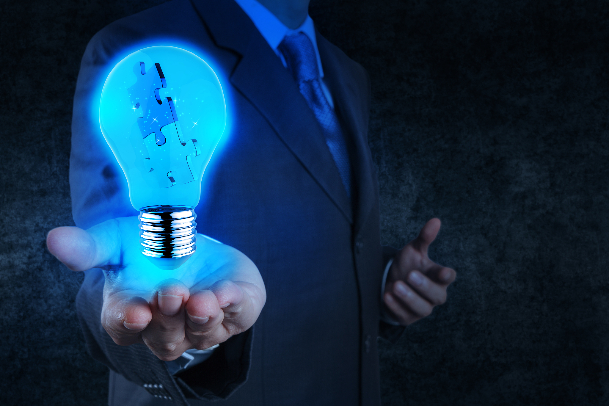 businessman hand shows light and puzzle partnership