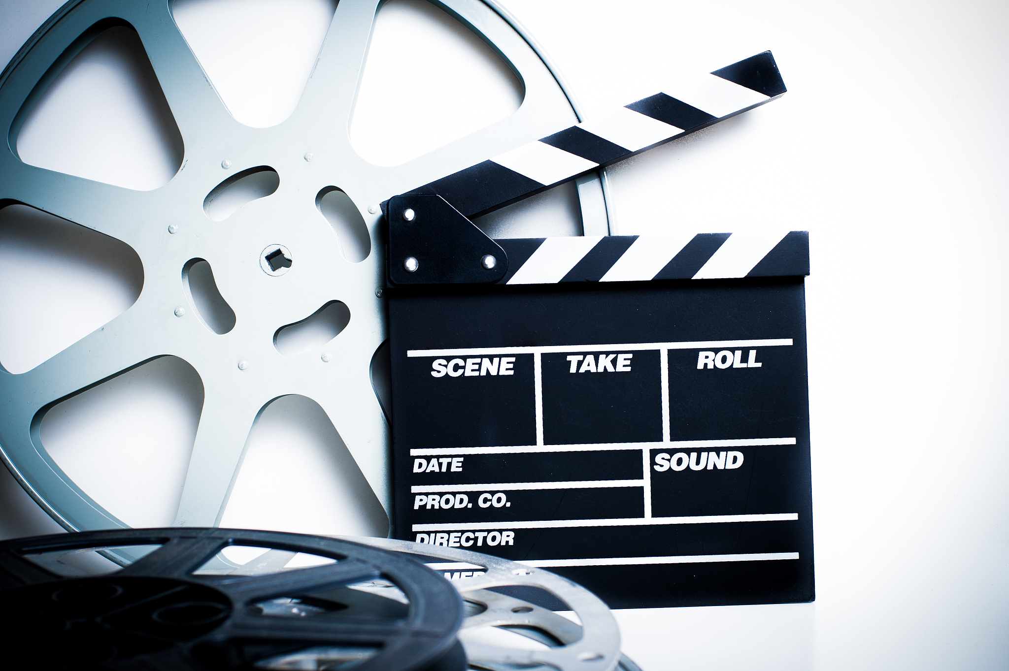 movie clapper with film reels on white